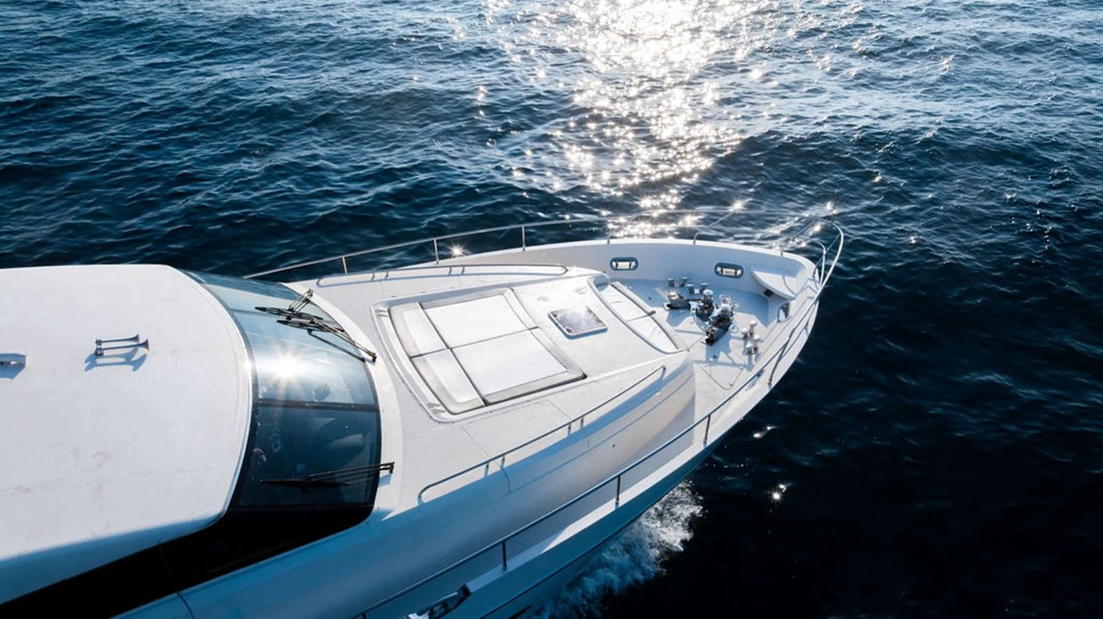 A sleek yacht glides through the water, showcasing its modern design and spacious deck. aboard OASIS Yacht for Sale