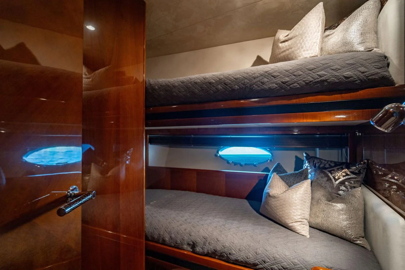 The guest cabin features cozy bunk beds with elegant bedding and a warm, inviting atmosphere. aboard OASIS Yacht for Sale