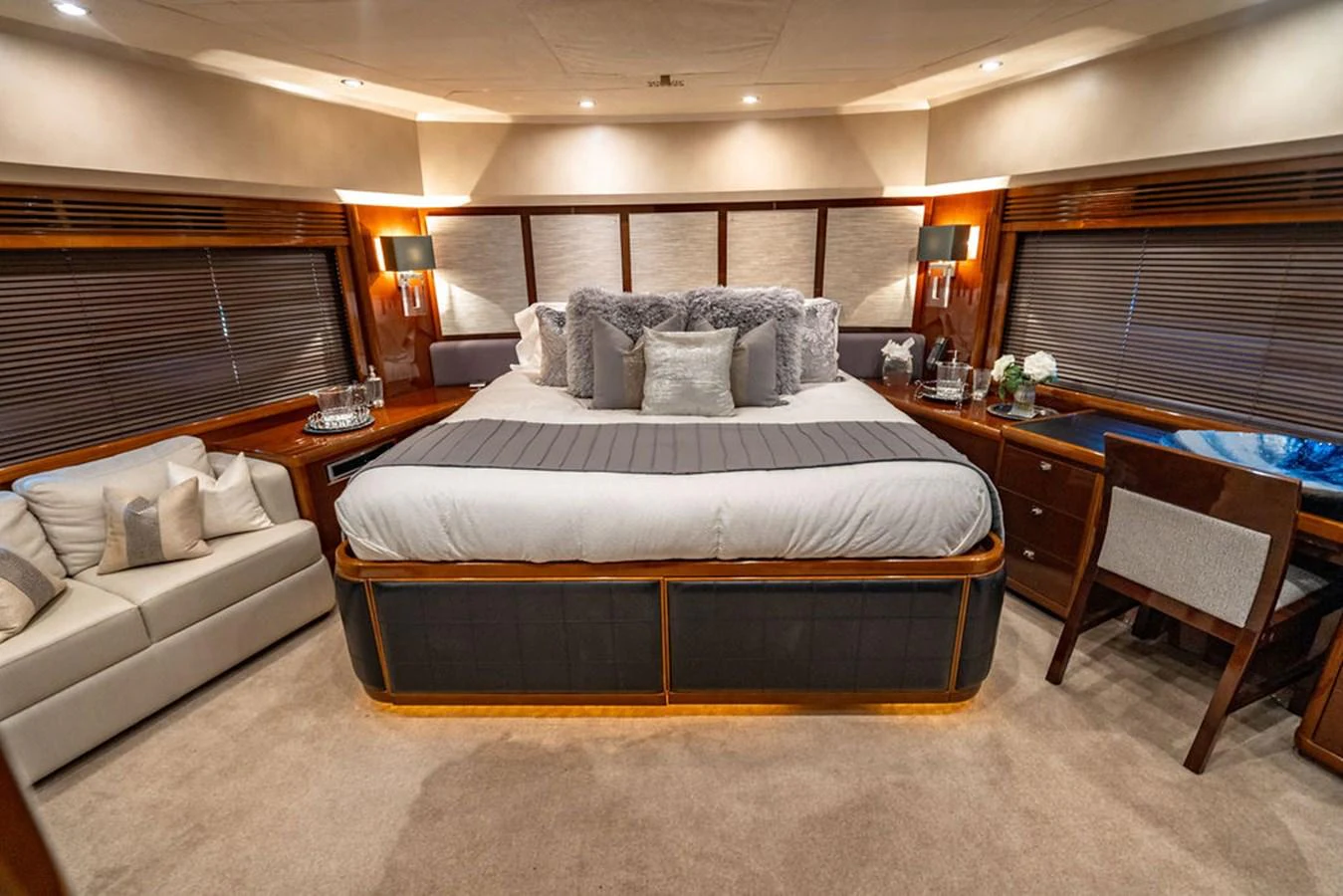 The master stateroom features a luxurious bed with plush pillows and elegant lighting. aboard OASIS Yacht for Sale