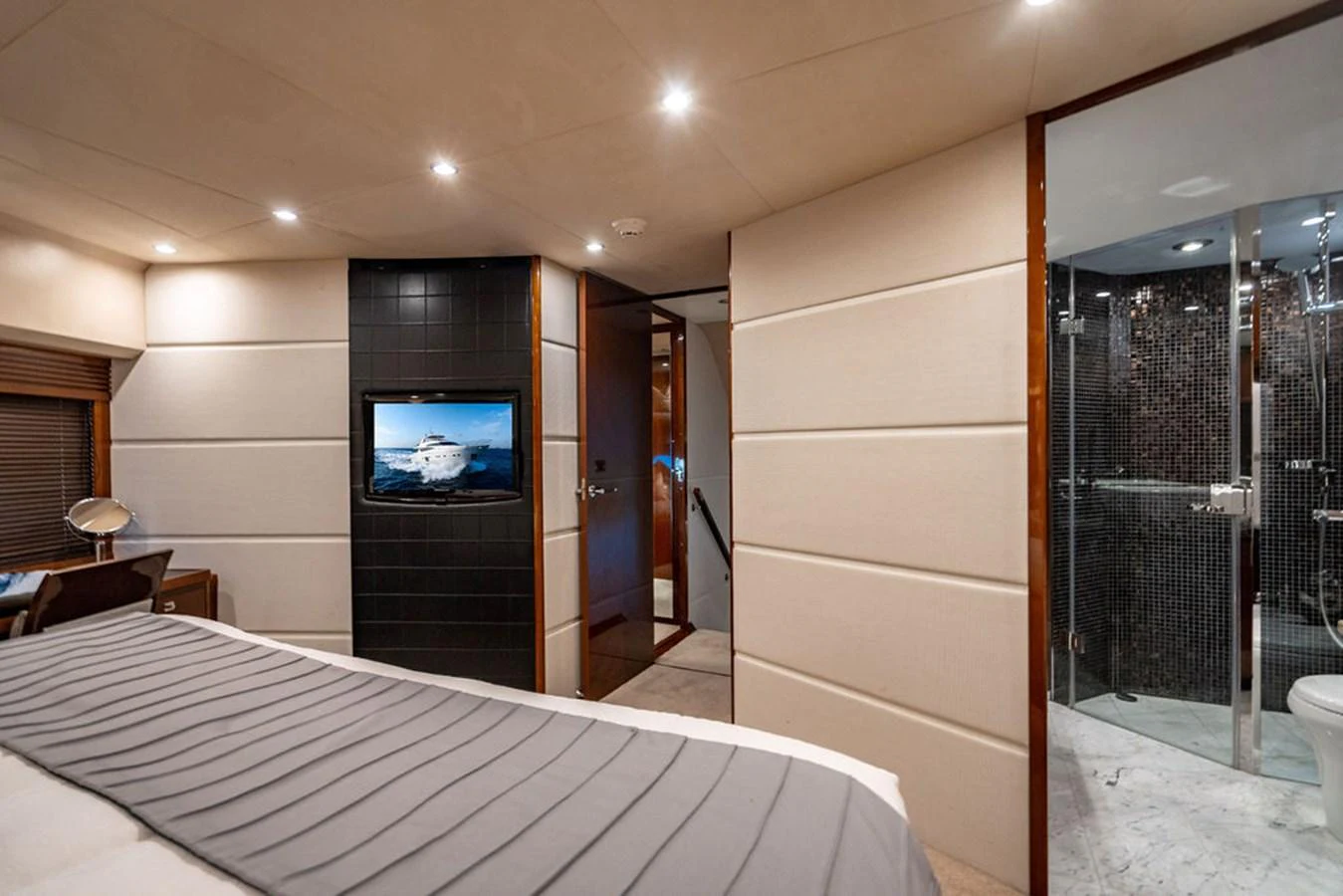 The stateroom features a luxurious bed, a flat-screen TV, and an en-suite bathroom with modern fixtures. aboard OASIS Yacht for Sale
