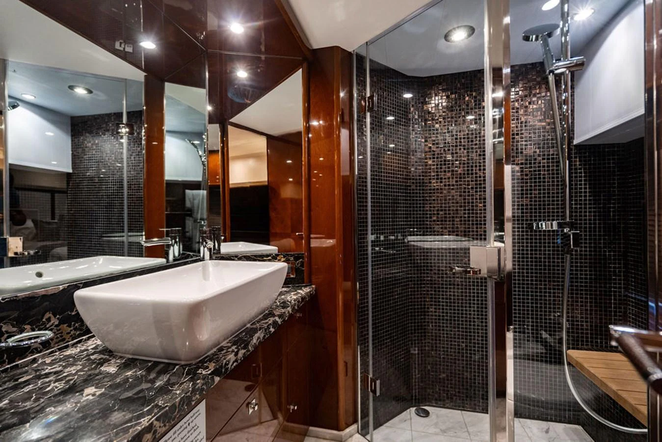The yacht's bathroom features a modern design with a sleek sink and a spacious shower area. aboard OASIS Yacht for Sale