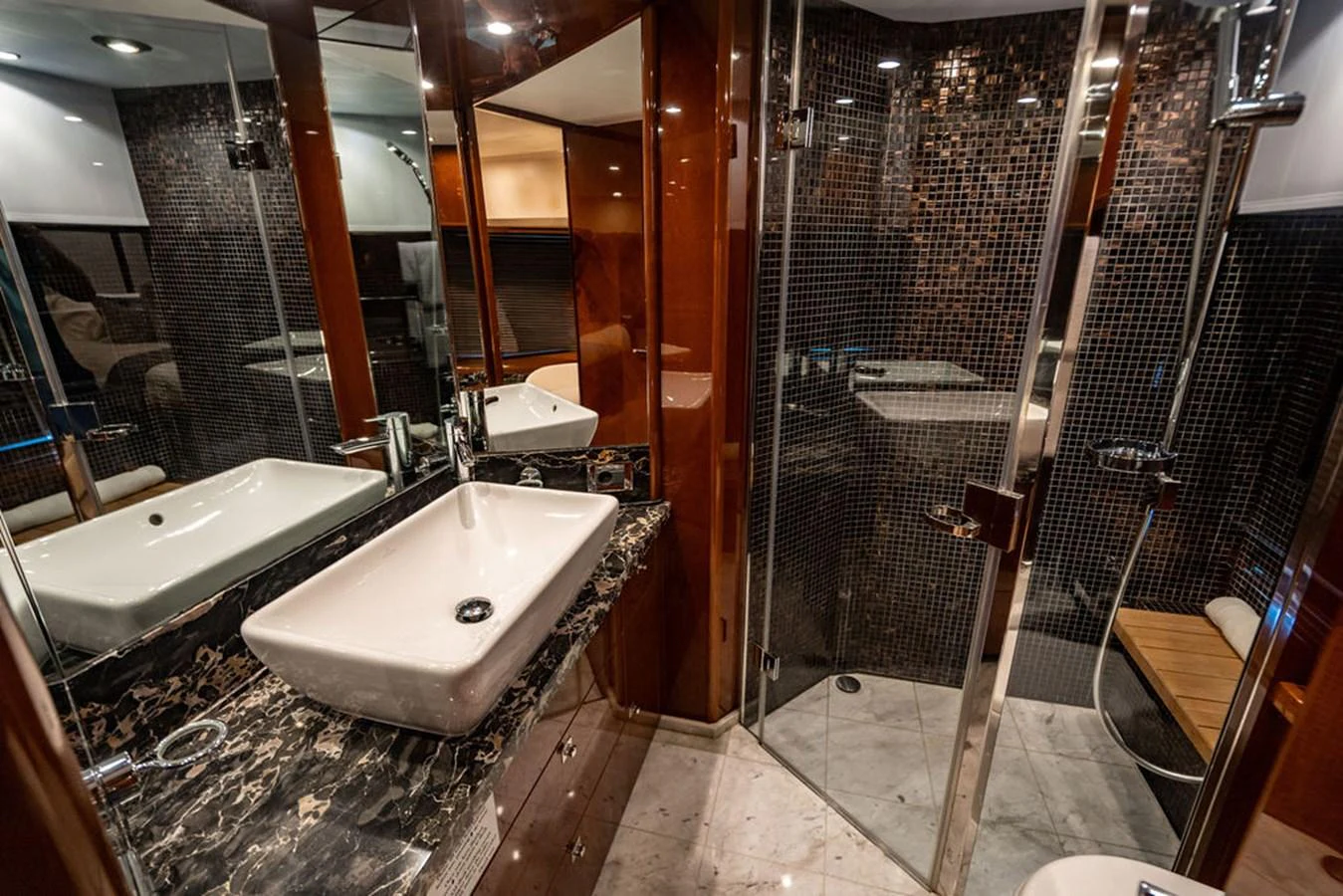 The yacht's bathroom features luxurious finishes with a sleek sink and a spacious shower area. aboard OASIS Yacht for Sale