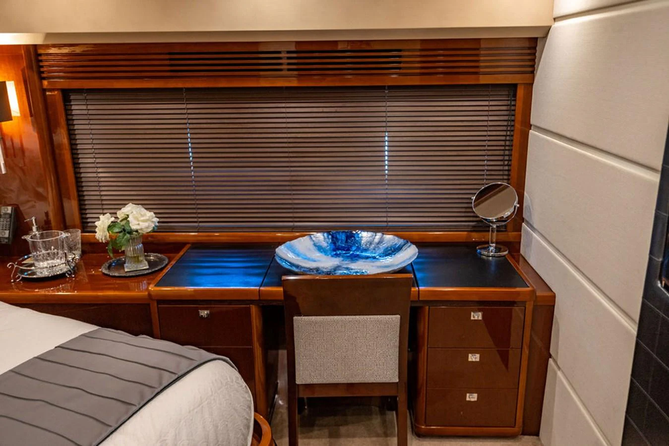 The stateroom features a sleek desk area with a decorative bowl and a comfortable chair. aboard OASIS Yacht for Sale