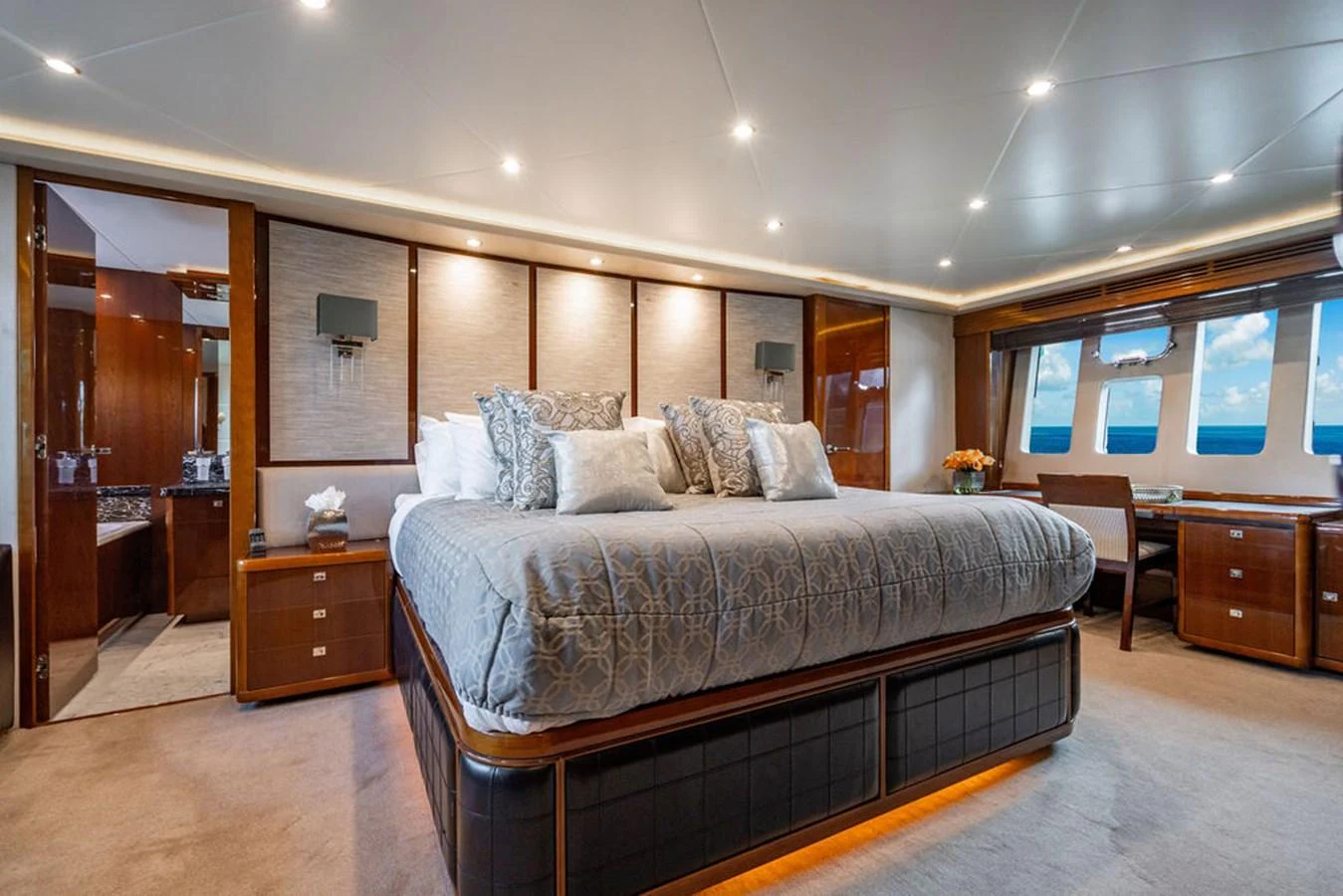 The master stateroom features a luxurious king-sized bed with elegant decor and ample natural light from large windows. aboard OASIS Yacht for Sale