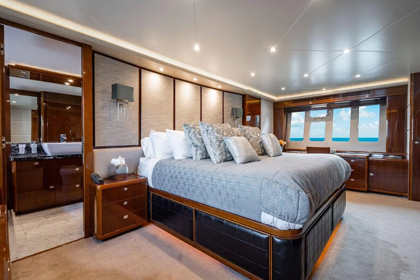 The master stateroom features a spacious bed with luxurious bedding and ample natural light from large windows. aboard OASIS Yacht for Sale
