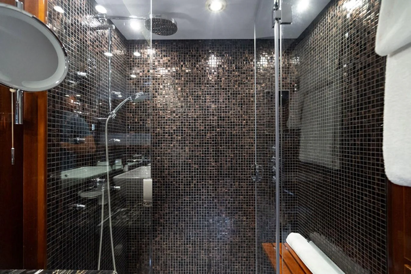 A luxurious yacht bathroom featuring a modern shower with mosaic tile walls. aboard OASIS Yacht for Sale