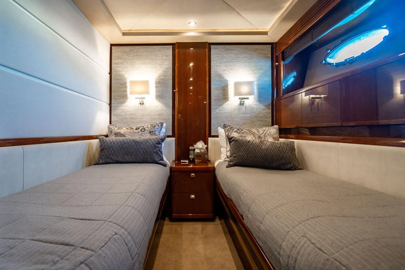 The twin stateroom features two comfortable single beds with elegant bedding and ambient lighting. aboard OASIS Yacht for Sale