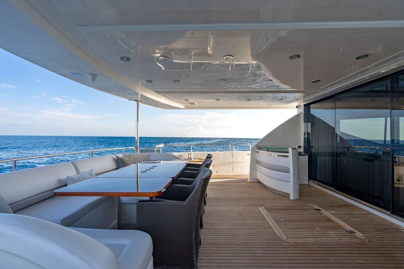 The aft deck offers a spacious and elegant outdoor dining area with stunning ocean views. aboard OASIS Yacht for Sale