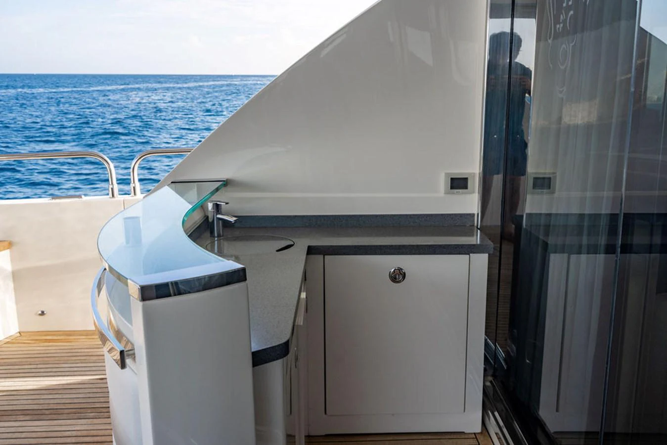 The yacht features a sleek outdoor bar area with a view of the ocean. aboard OASIS Yacht for Sale
