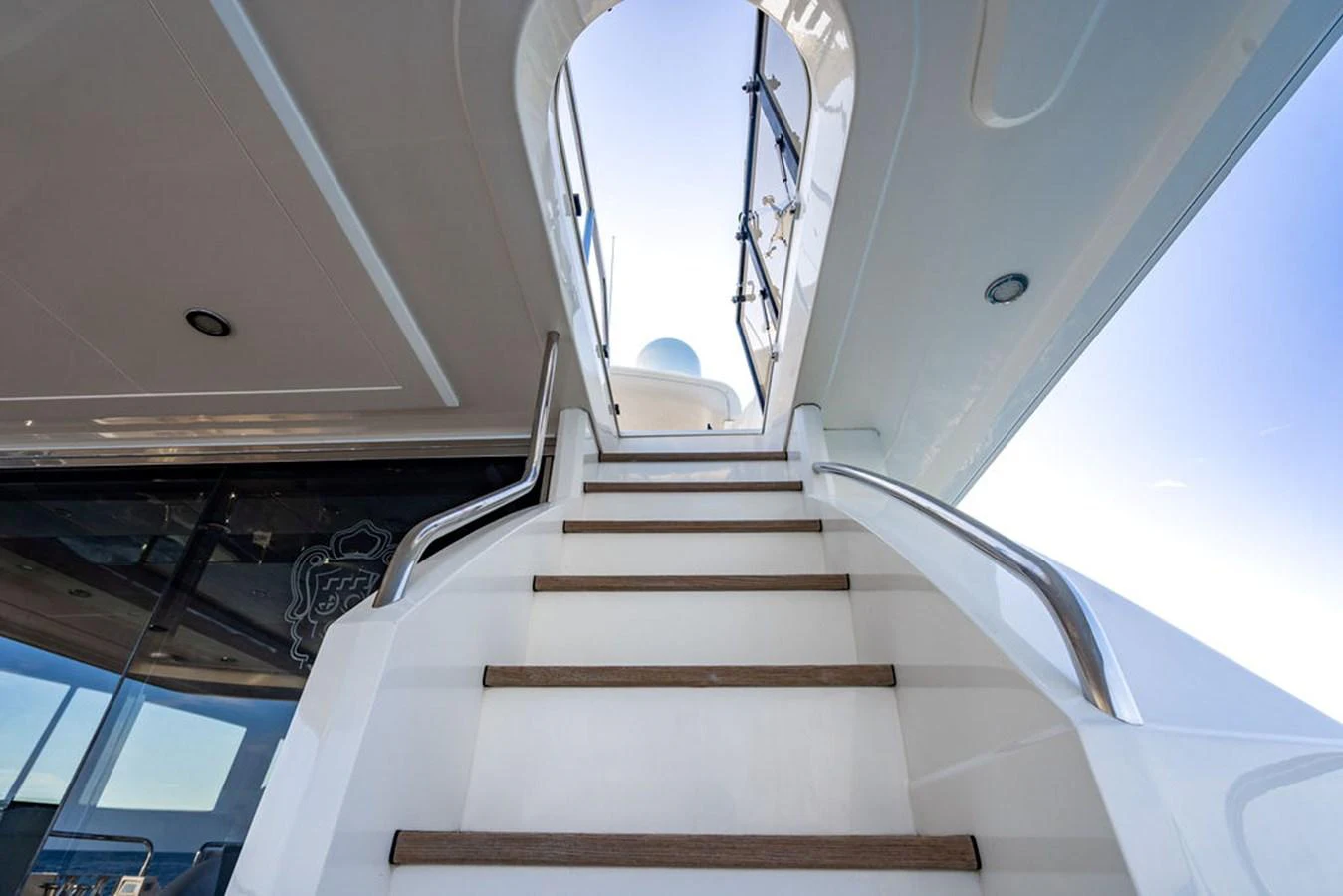 A sleek staircase leads to the upper deck, showcasing modern design and craftsmanship. aboard OASIS Yacht for Sale