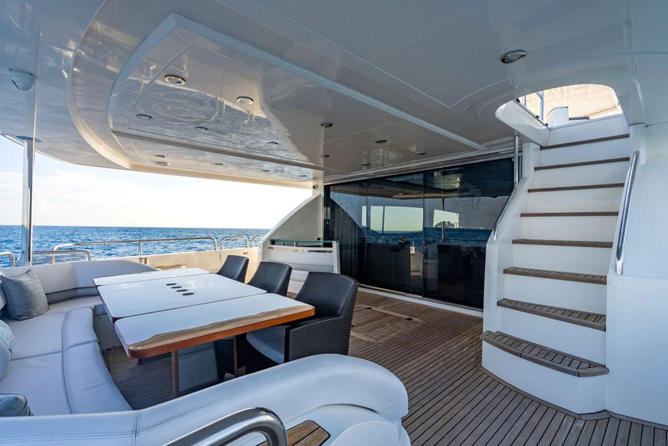 The aft deck offers a spacious and elegant outdoor dining area with comfortable seating and direct access to the interior. aboard OASIS Yacht for Sale