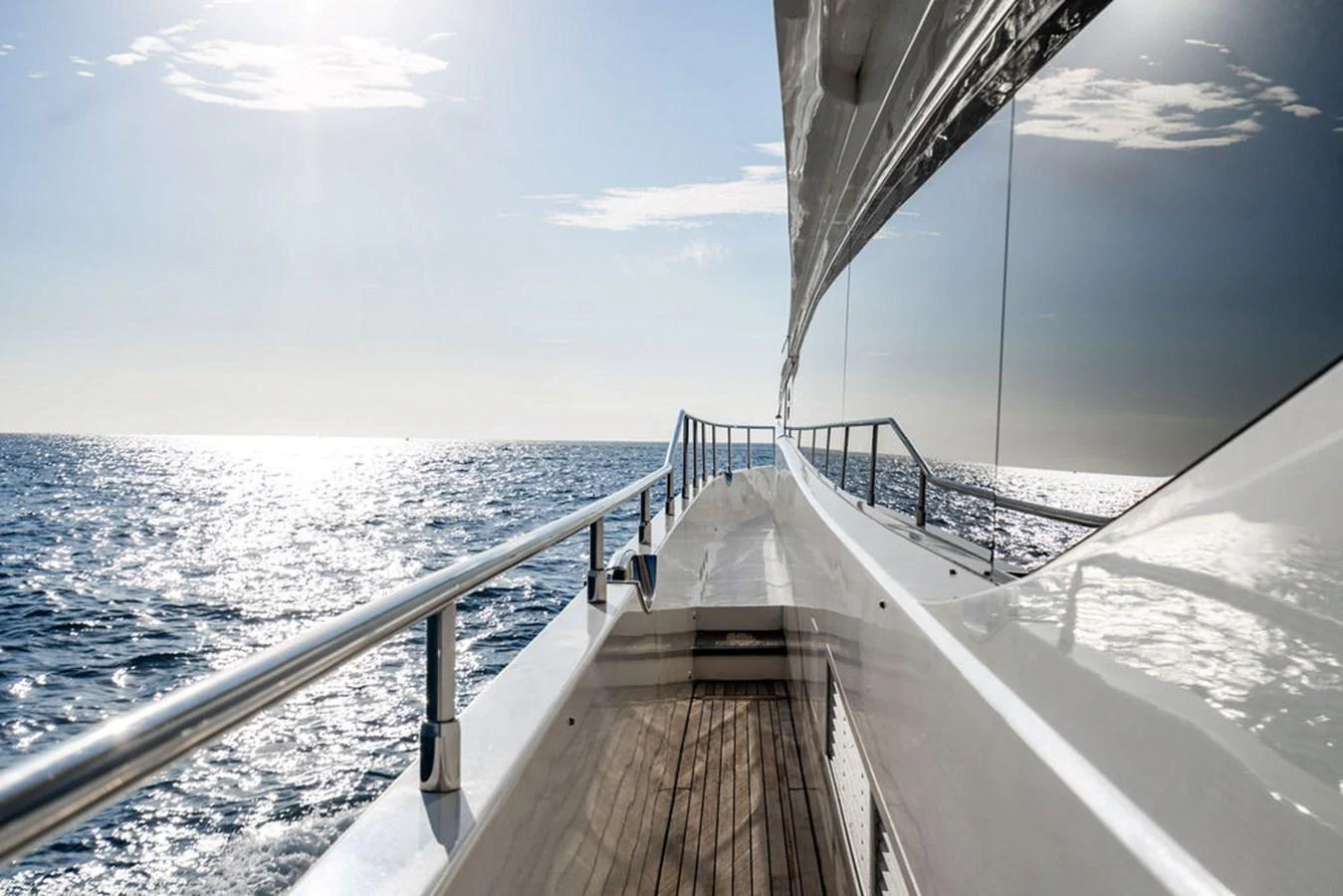 A sleek yacht deck with polished railings and a stunning ocean view. aboard OASIS Yacht for Sale