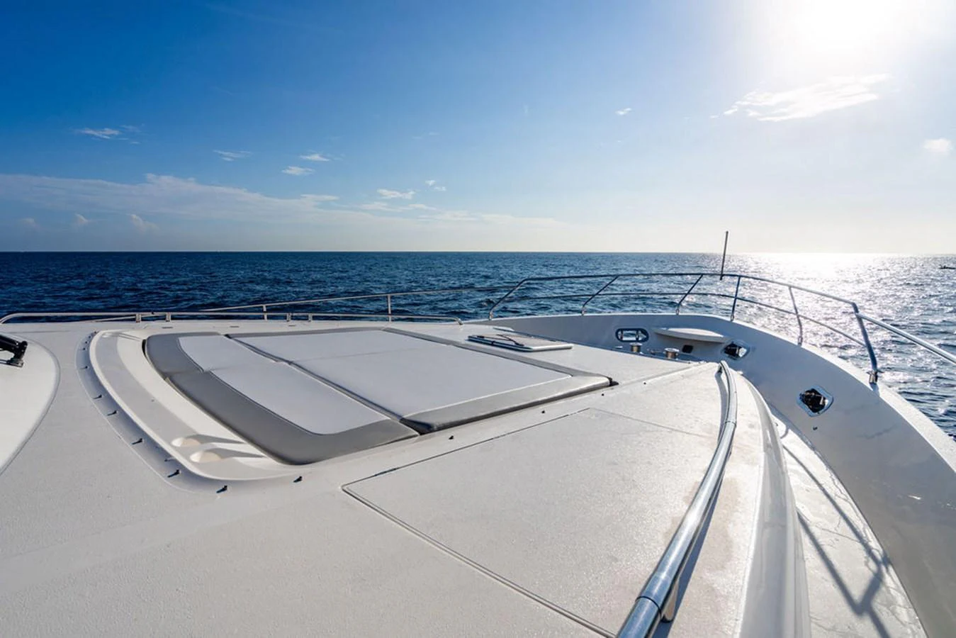 The yacht's foredeck features spacious sun pads for relaxation under the clear blue sky. aboard OASIS Yacht for Sale