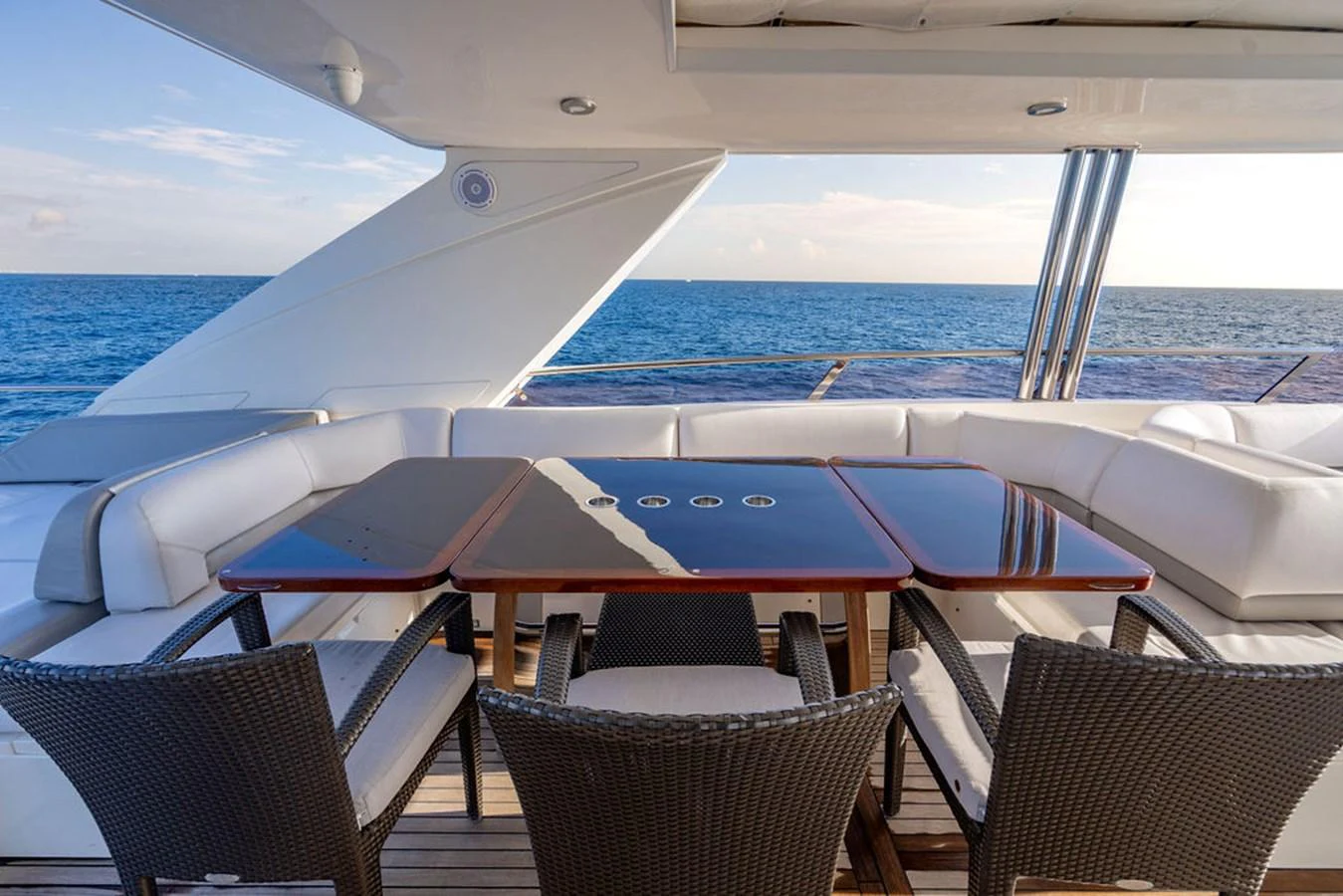The aft deck features a stylish dining area with a sleek table and comfortable seating, perfect for al fresco meals with a view of the sea. aboard OASIS Yacht for Sale