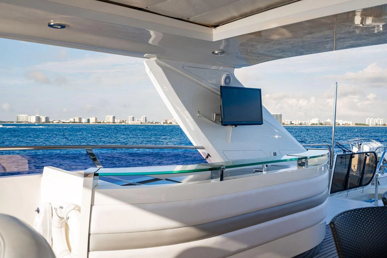 The yacht features a stylish outdoor bar area with a TV, perfect for entertainment while enjoying the sea view. aboard OASIS Yacht for Sale