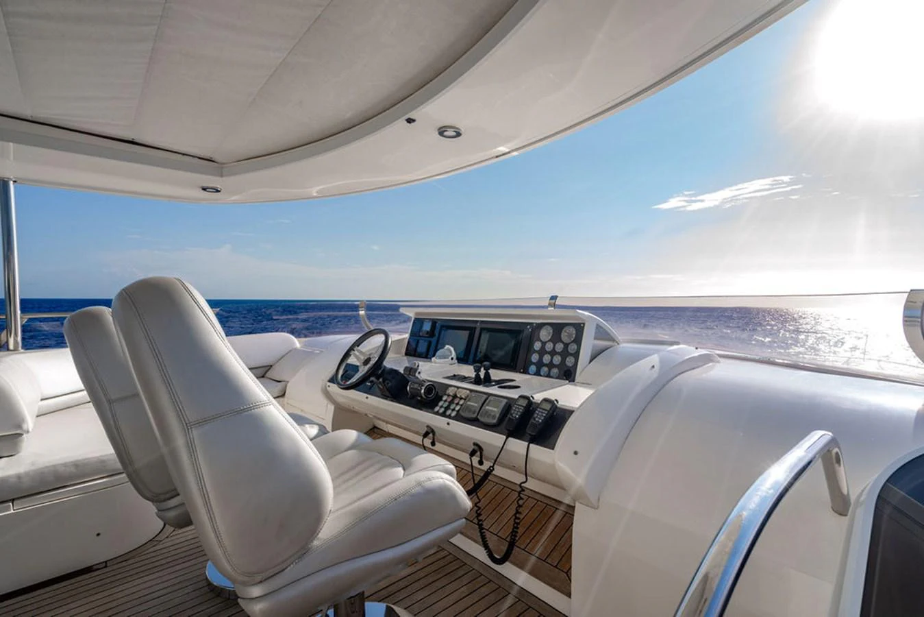 The helm station offers a commanding view of the open sea with luxurious seating and advanced navigation equipment. aboard OASIS Yacht for Sale