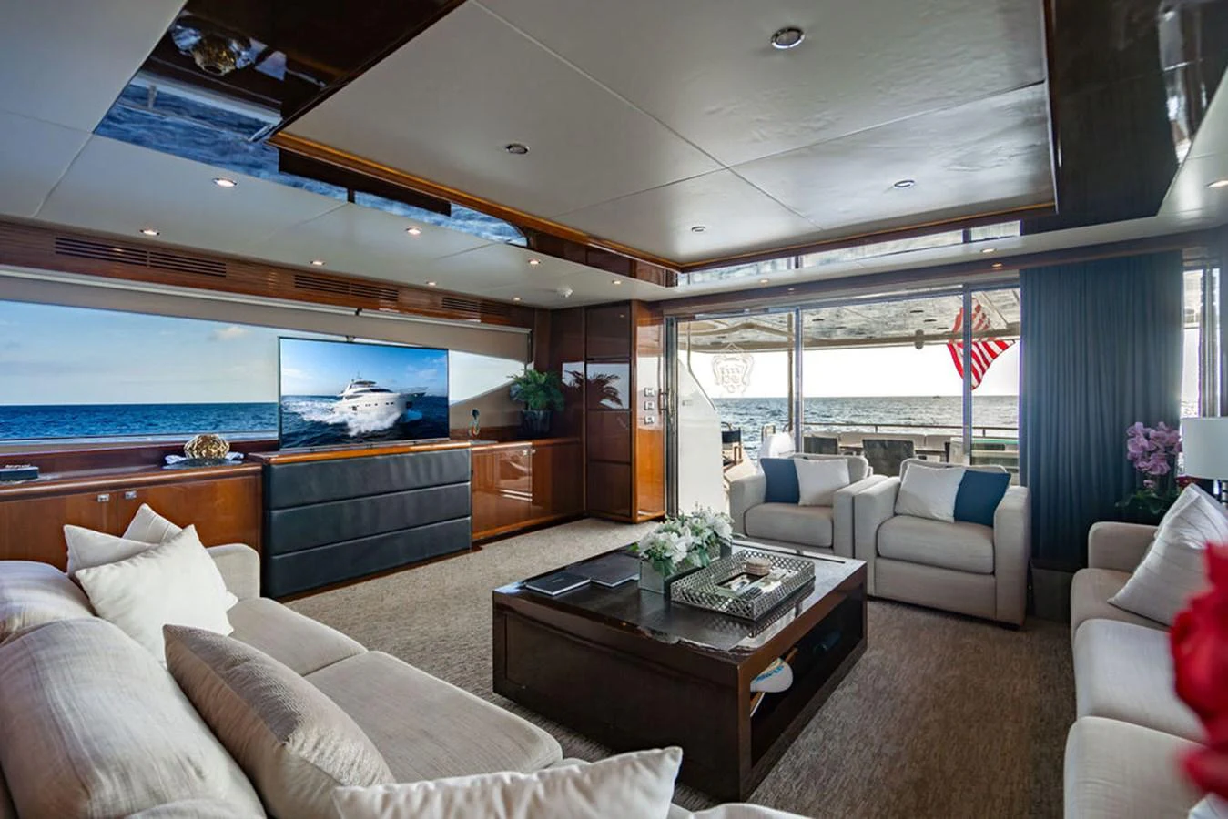 The salon offers a spacious and elegant living area with plush seating and a large TV, perfect for relaxation and entertainment. aboard OASIS Yacht for Sale