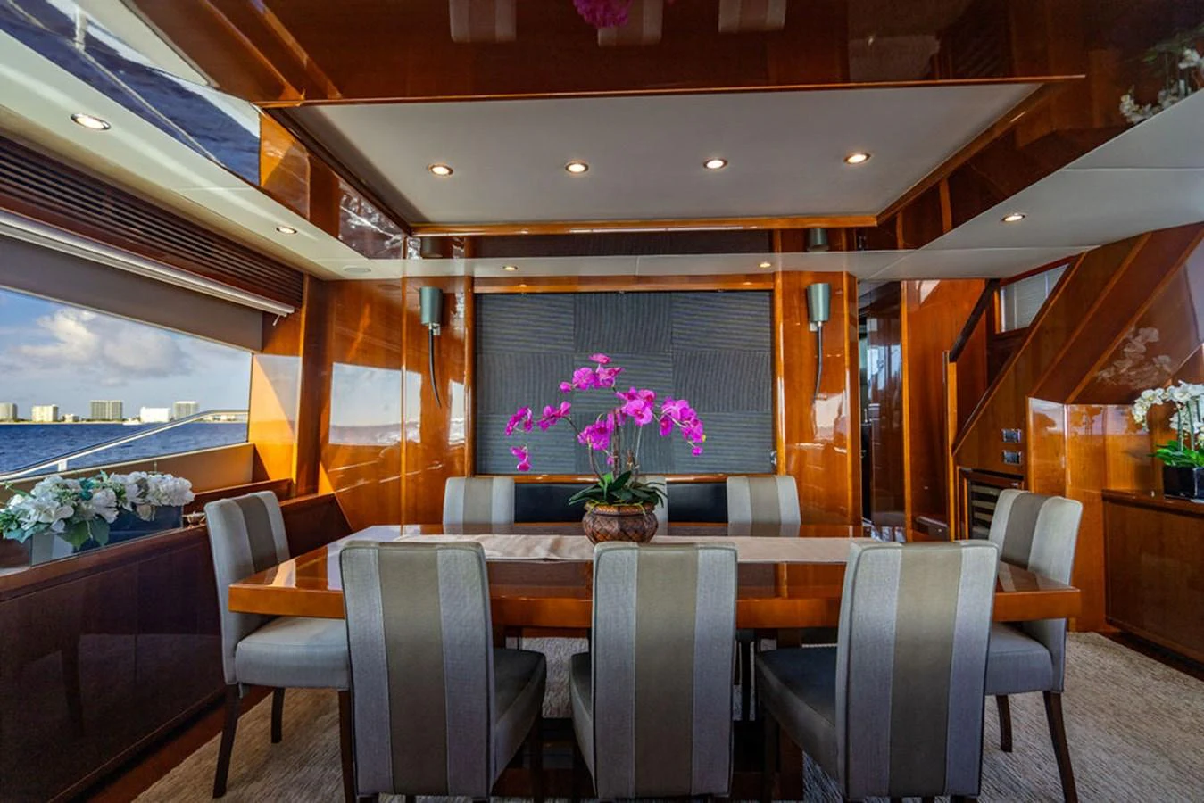 The yacht's dining area features elegant seating and a vibrant floral centerpiece. aboard OASIS Yacht for Sale