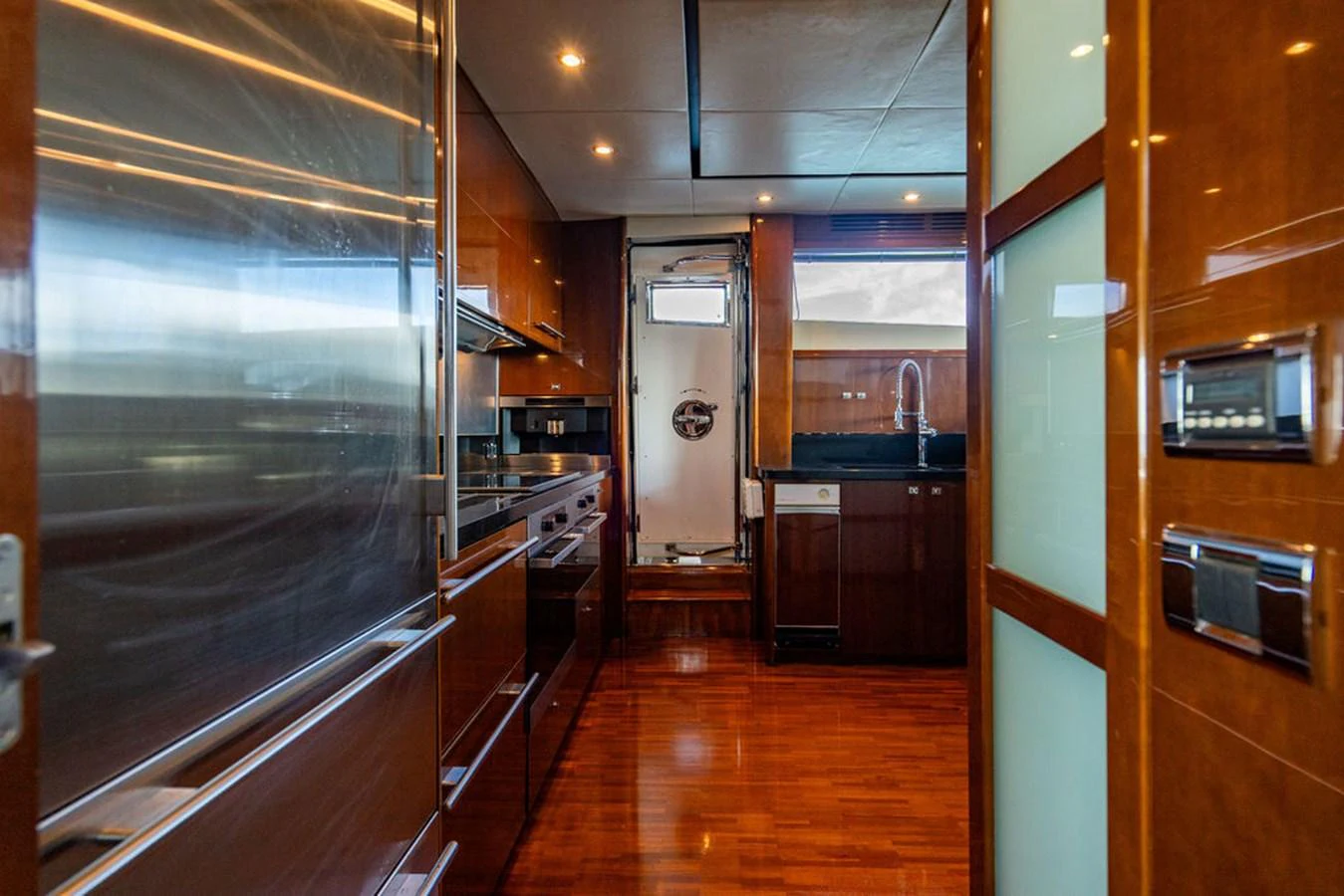 The yacht's galley features modern appliances and rich wood finishes, creating a warm and functional space. aboard OASIS Yacht for Sale