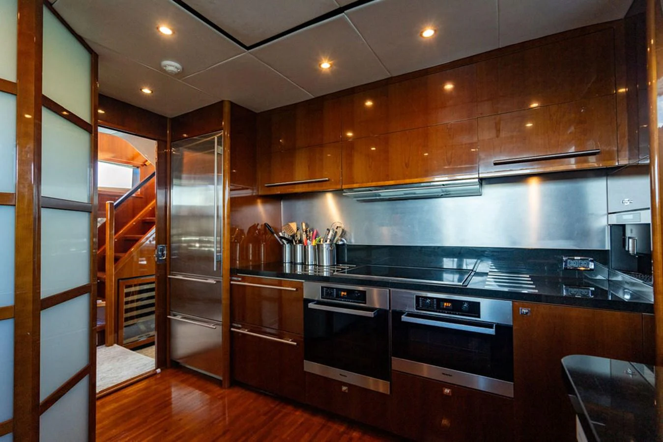 The yacht's galley features modern appliances and sleek wooden cabinetry. aboard OASIS Yacht for Sale