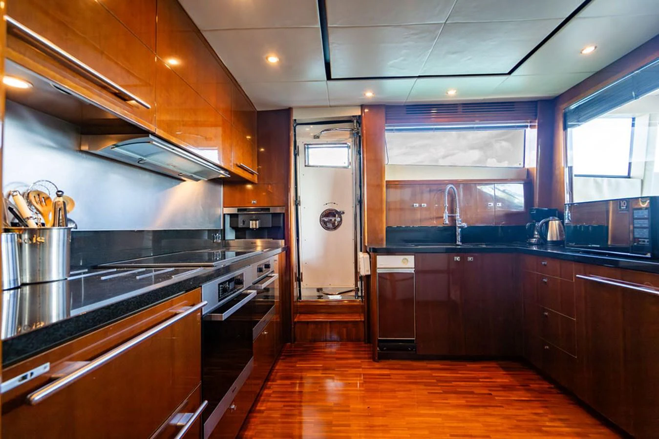 The yacht's galley features modern appliances and sleek wooden cabinetry, creating a warm and functional space. aboard OASIS Yacht for Sale