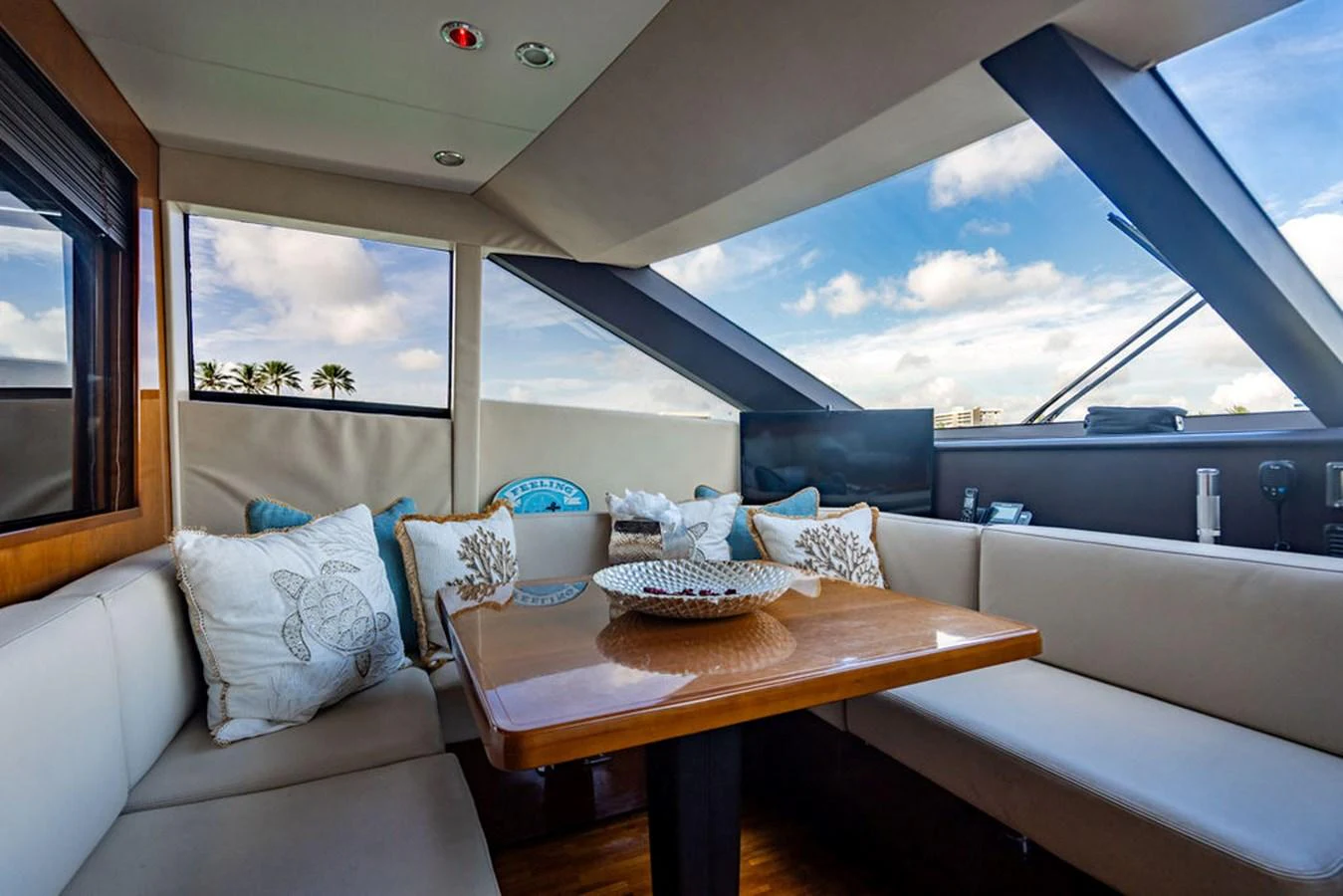 The yacht's salon features a cozy seating area with large windows offering stunning views. aboard OASIS Yacht for Sale