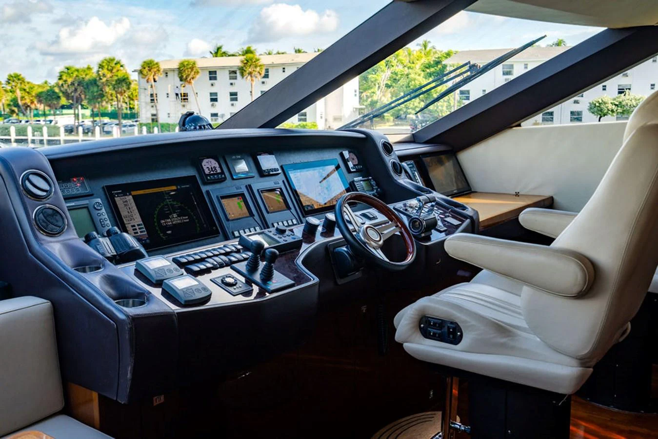 The helm station features advanced navigation equipment and a comfortable captain's chair, offering a commanding view for smooth sailing. aboard OASIS Yacht for Sale