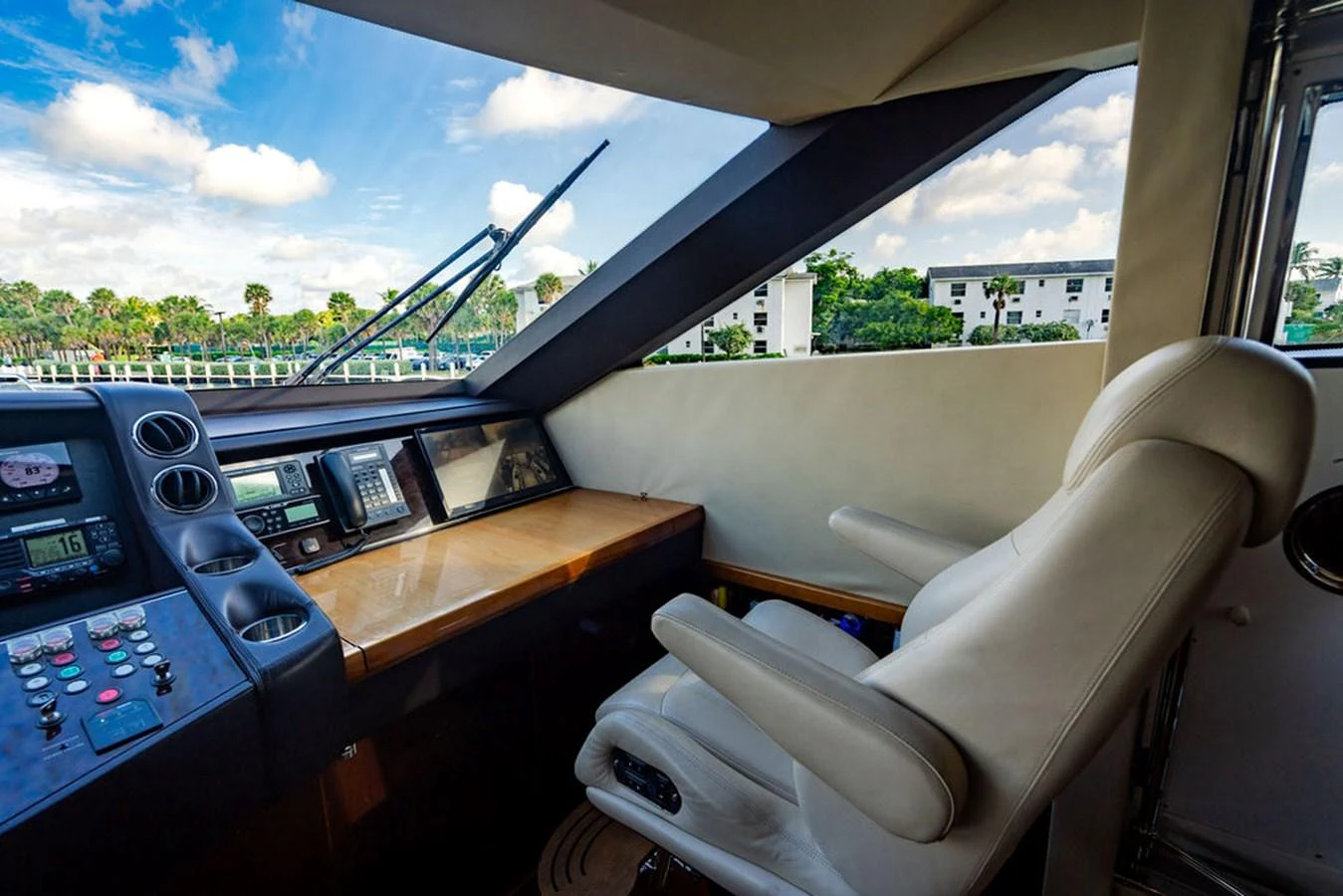 The helm station offers a commanding view with modern navigation equipment and a comfortable captain's chair. aboard OASIS Yacht for Sale