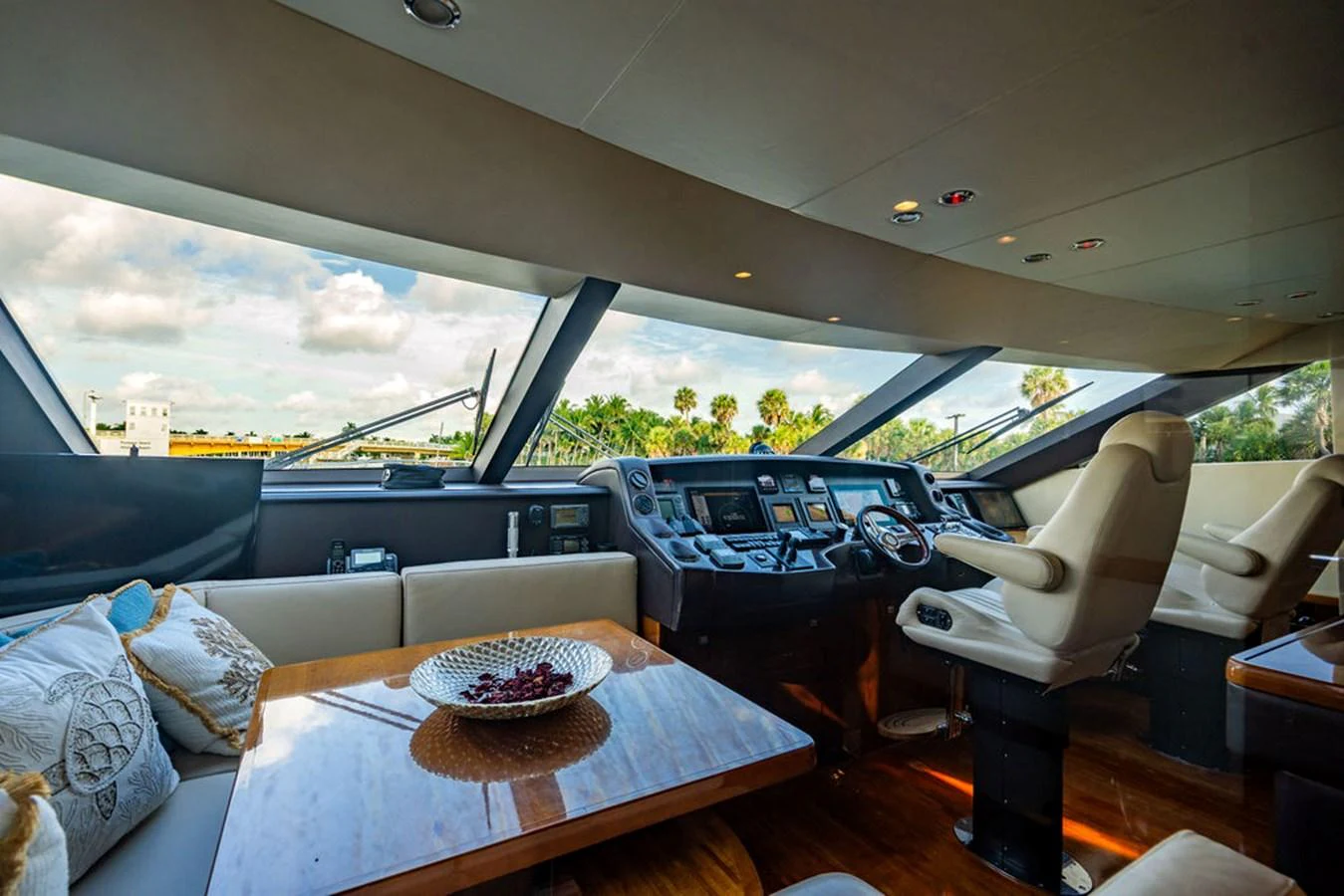 The helm area features a luxurious seating arrangement with expansive windows offering panoramic views. aboard OASIS Yacht for Sale