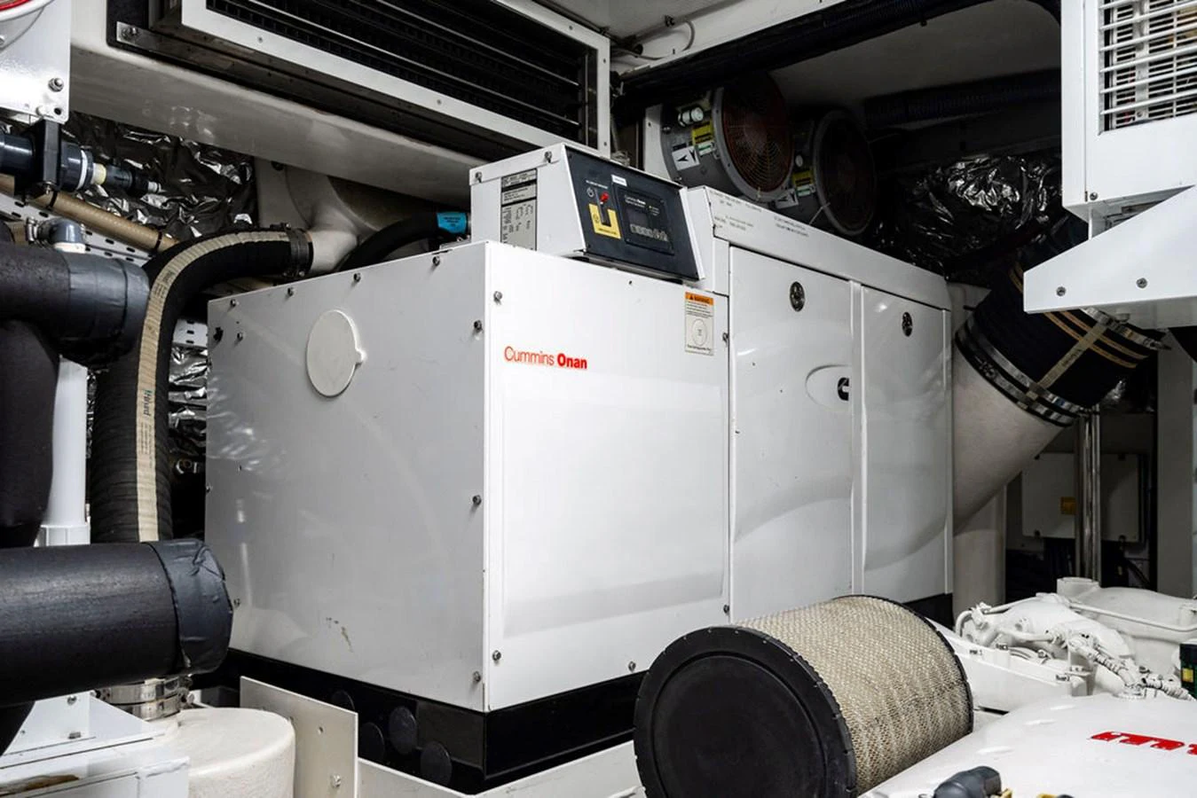 The image showcases the yacht's engine room with a Cummins Onan generator. aboard OASIS Yacht for Sale