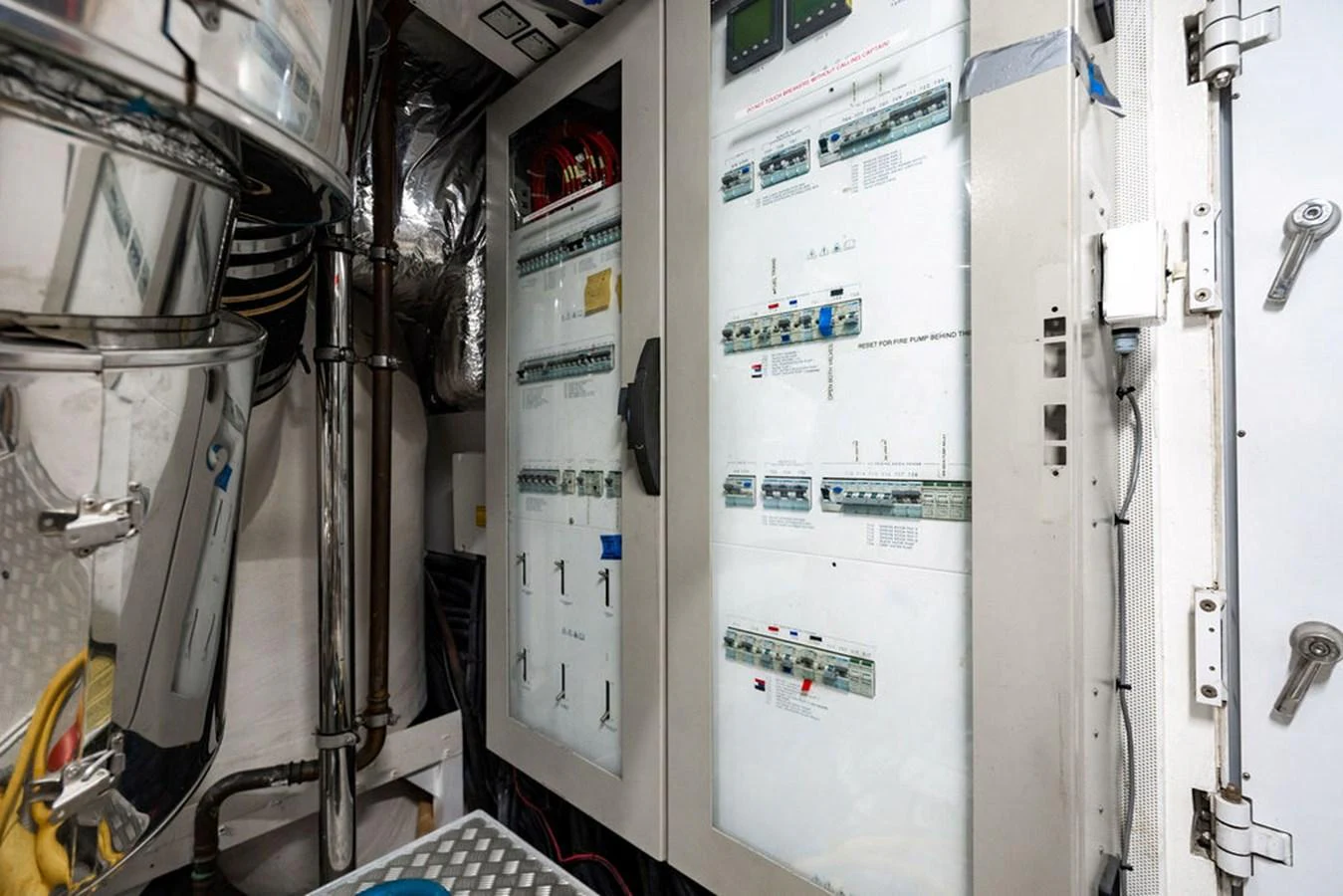 The image showcases the yacht's engine room with detailed electrical panels and equipment. aboard OASIS Yacht for Sale
