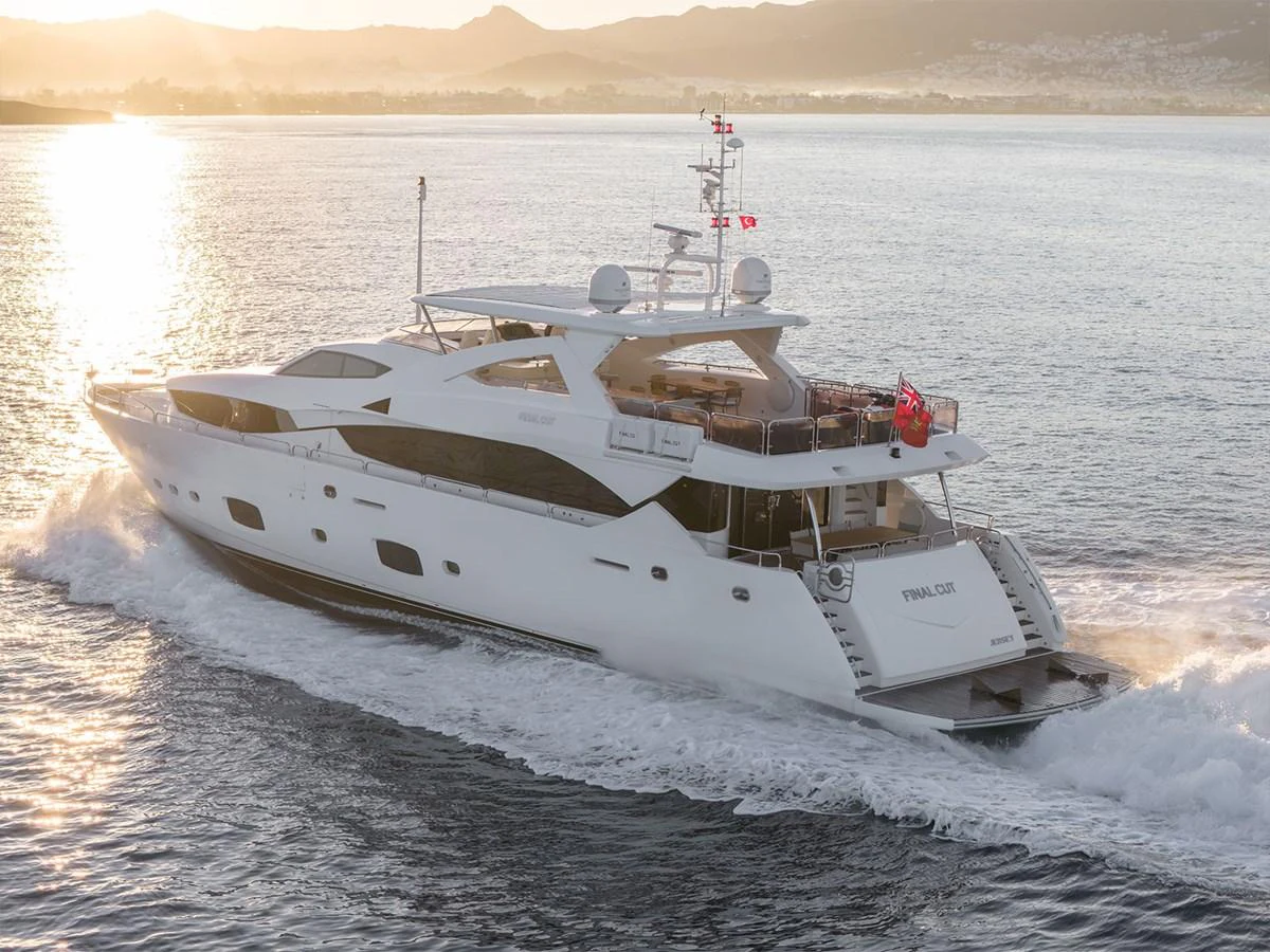 A luxurious yacht cruises through the water at sunset, showcasing its sleek design and spacious decks. aboard FINAL CUT Yacht for Sale