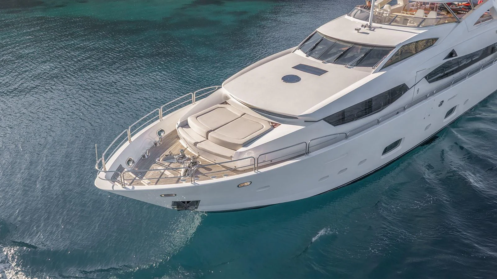 A sleek and modern yacht glides gracefully on clear blue waters, showcasing its elegant design. aboard FINAL CUT Yacht for Sale