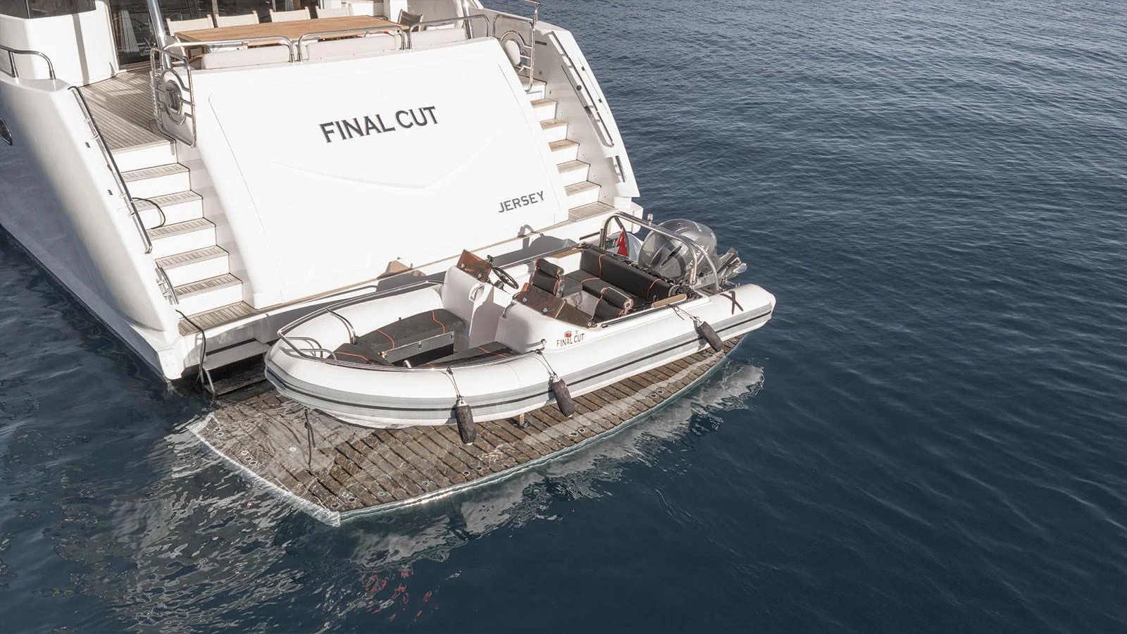 A sleek tender is docked at the stern of a yacht, ready for excursions. aboard FINAL CUT Yacht for Sale