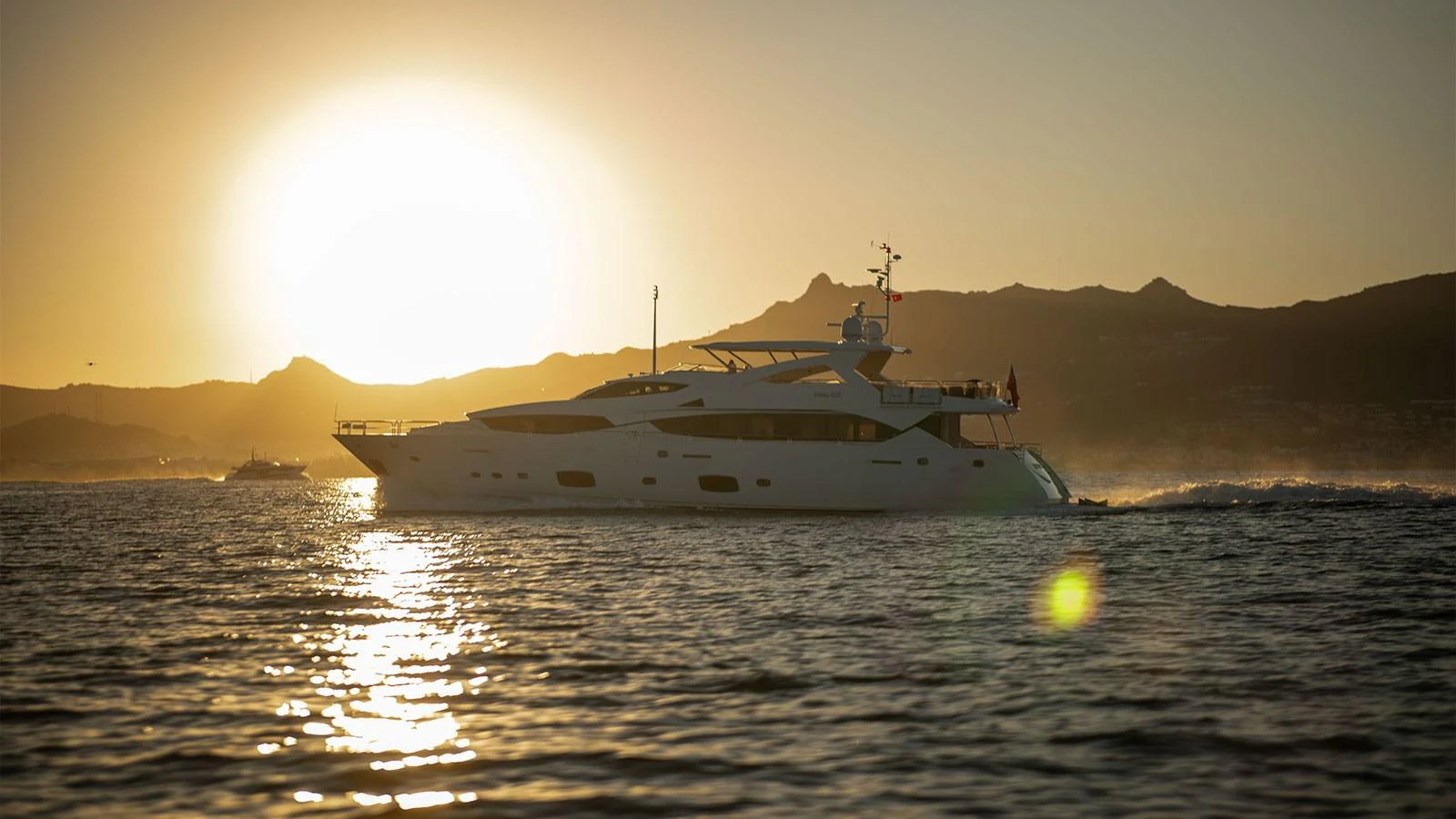 A luxurious yacht cruises through the water at sunset, creating a serene and elegant scene. aboard FINAL CUT Yacht for Sale