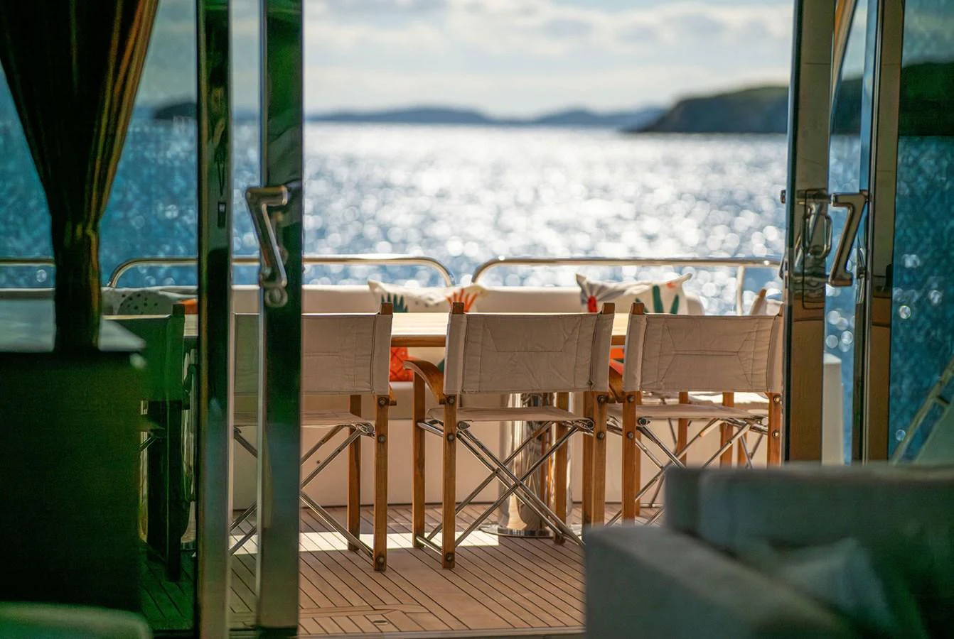 The aft deck offers a serene dining area with a stunning view of the water. aboard FINAL CUT Yacht for Sale