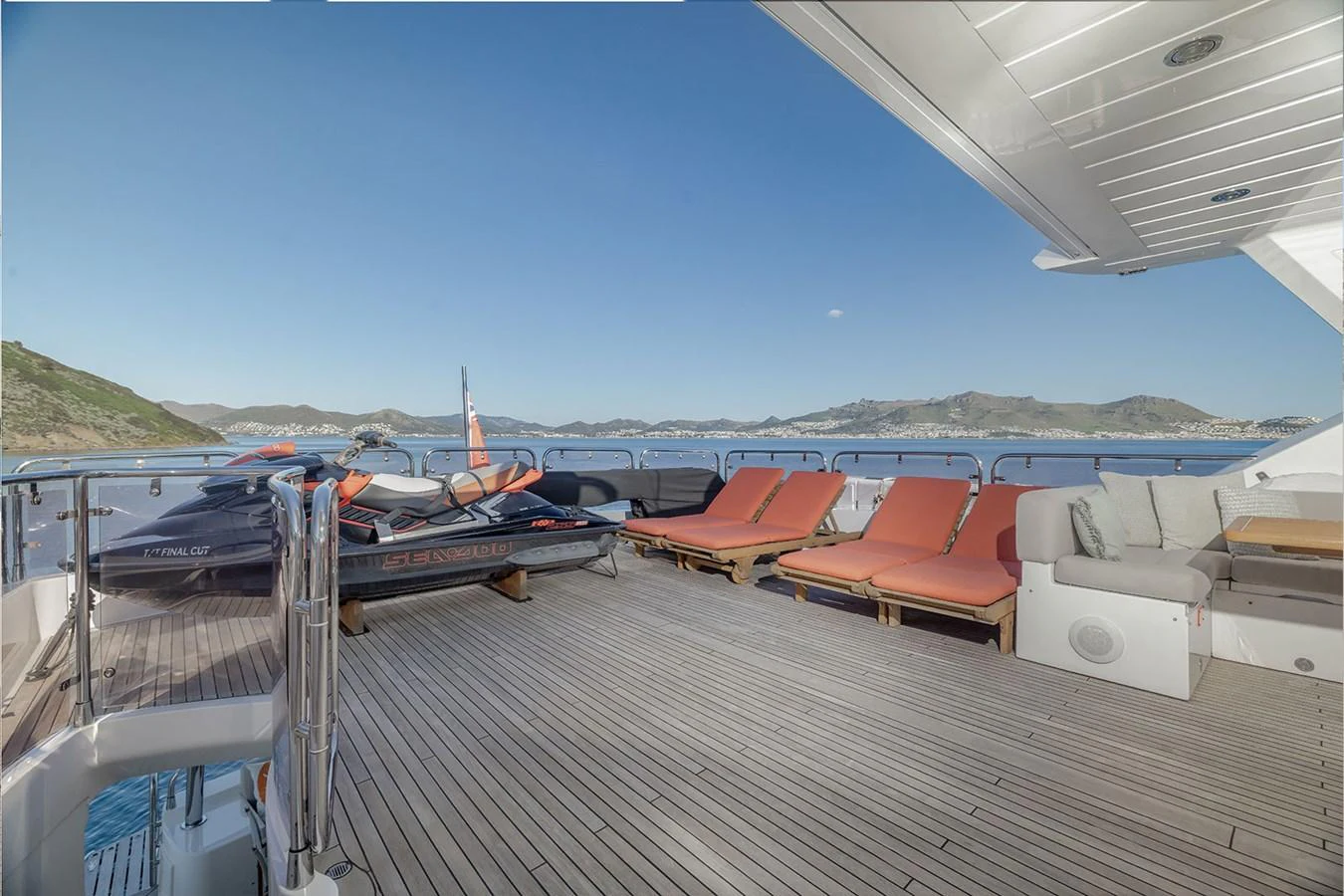 The aft deck features comfortable lounge chairs and a jet ski, offering a perfect spot for relaxation and water activities. aboard FINAL CUT Yacht for Sale