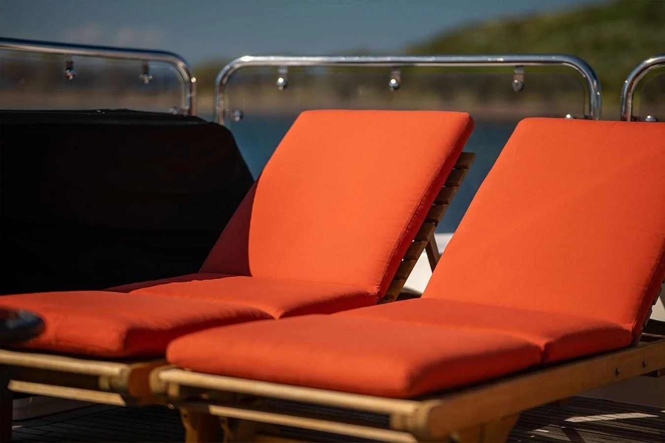 The image showcases two vibrant orange sun loungers on the sundeck, perfect for relaxation. aboard FINAL CUT Yacht for Sale