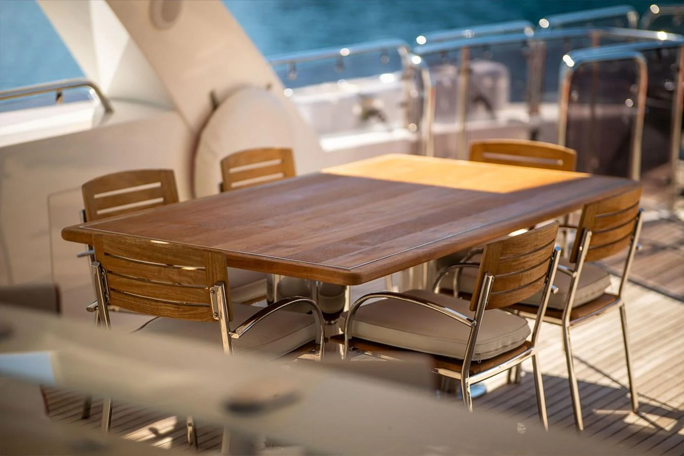 The aft deck features a stylish dining area with a wooden table and comfortable chairs, perfect for alfresco meals. aboard FINAL CUT Yacht for Sale