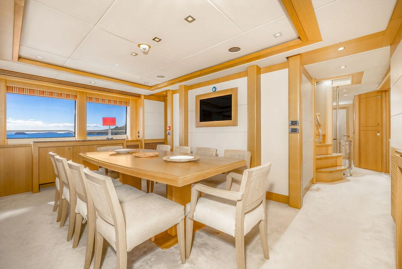 The dining area features a spacious table with comfortable seating and large windows offering stunning ocean views. aboard FINAL CUT Yacht for Sale