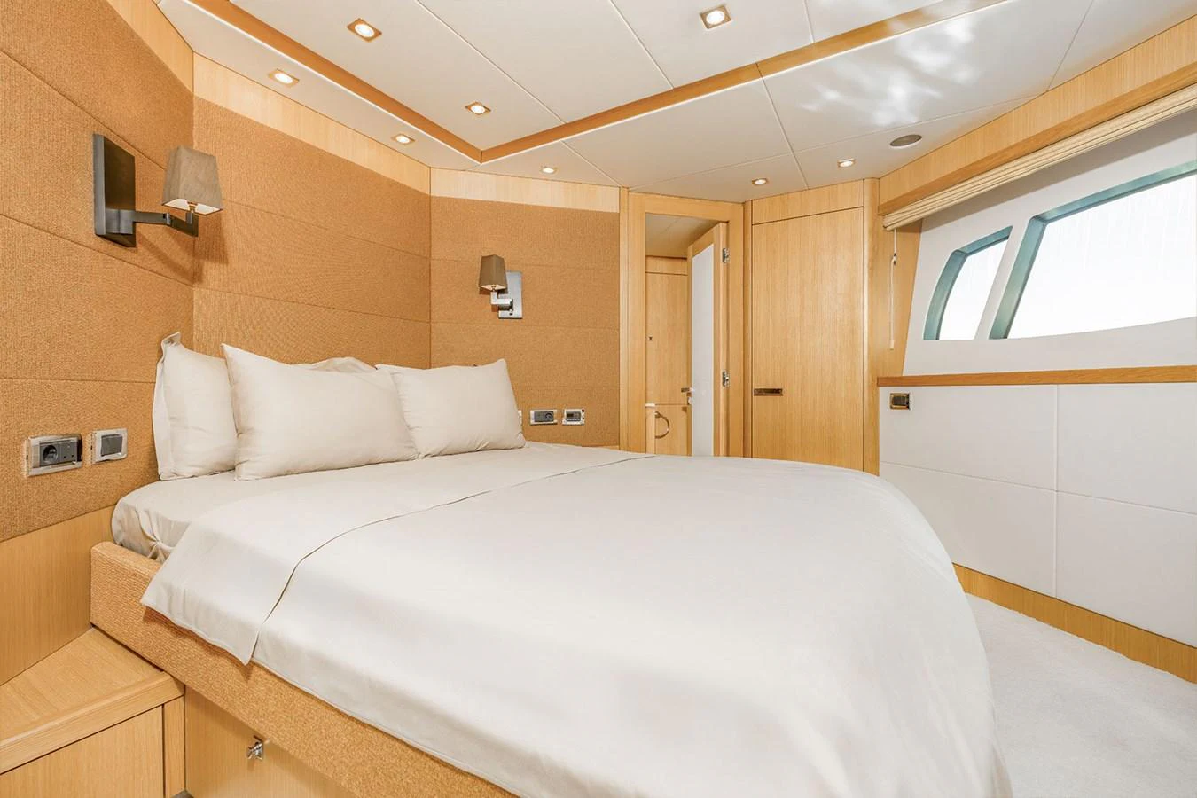 The stateroom features a spacious bed with modern lighting and ample natural light from the windows. aboard FINAL CUT Yacht for Sale