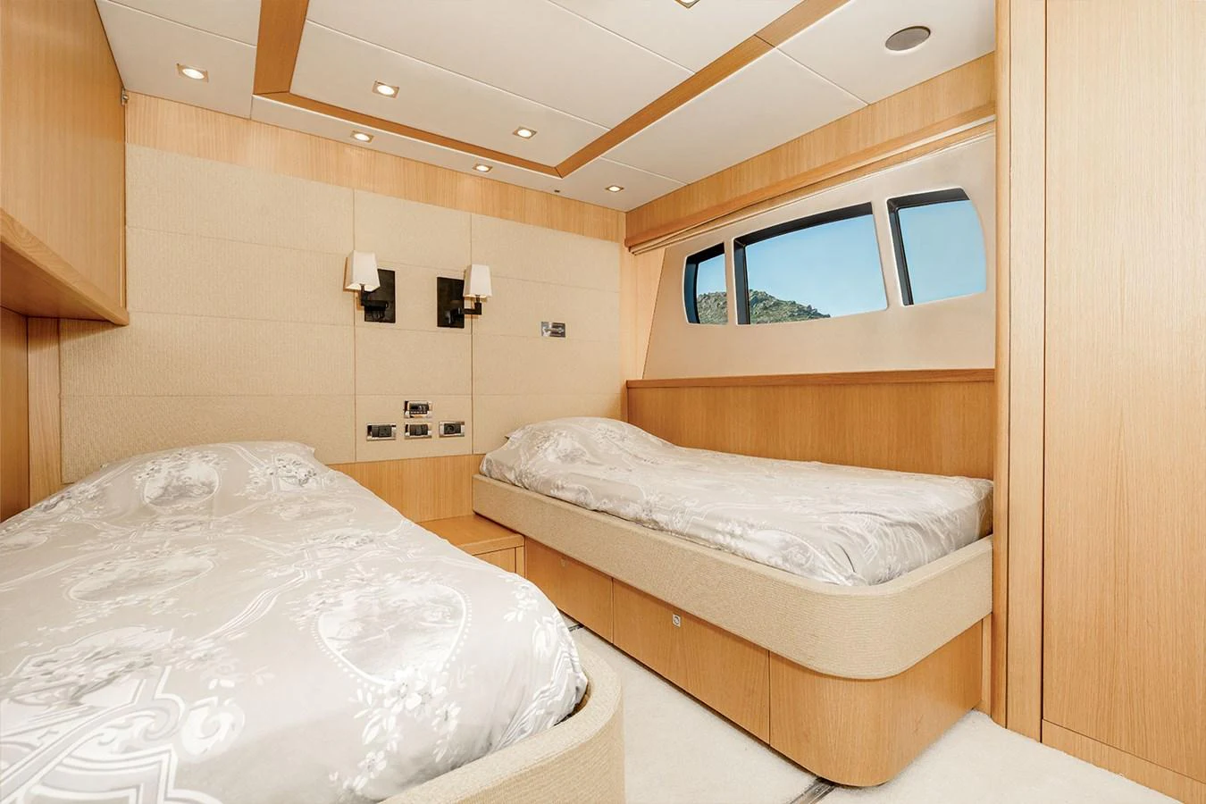 The guest stateroom features twin beds and a serene, well-lit atmosphere with natural wood finishes. aboard FINAL CUT Yacht for Sale