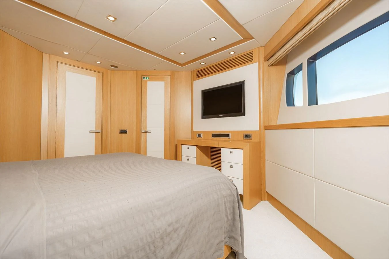 The stateroom features a comfortable bed, modern furnishings, and ample natural light from the large window. aboard FINAL CUT Yacht for Sale