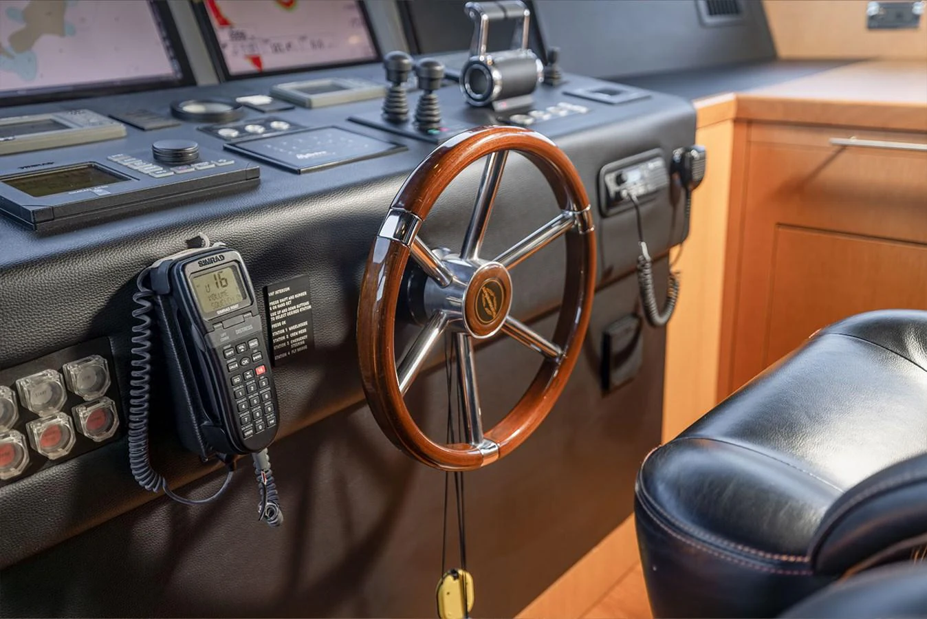 The helm station features a polished wooden steering wheel and advanced navigation equipment. aboard FINAL CUT Yacht for Sale
