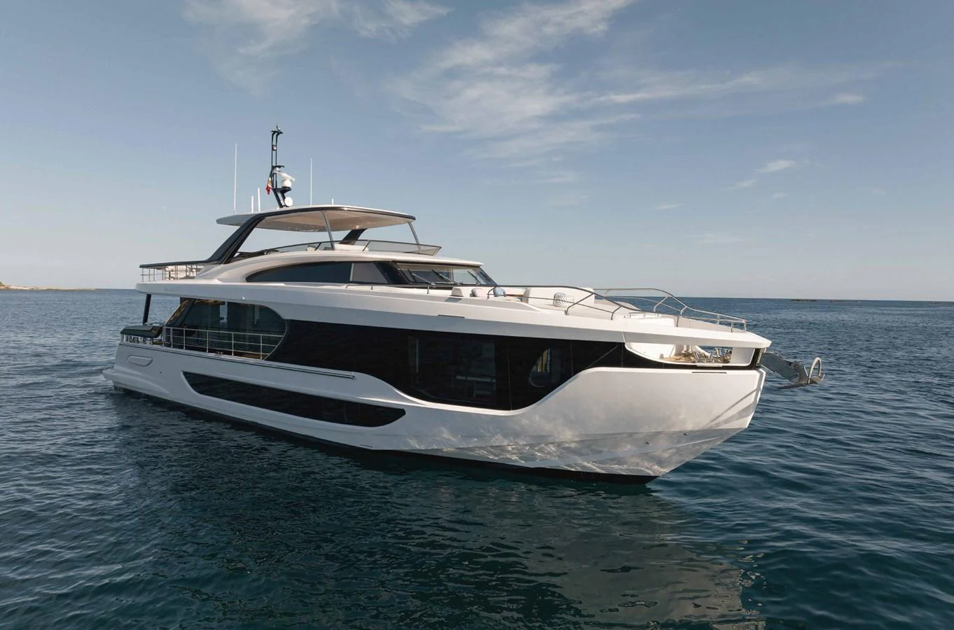 A sleek and modern yacht glides gracefully on the calm waters under a clear sky. aboard MARYBELLE Yacht for Sale