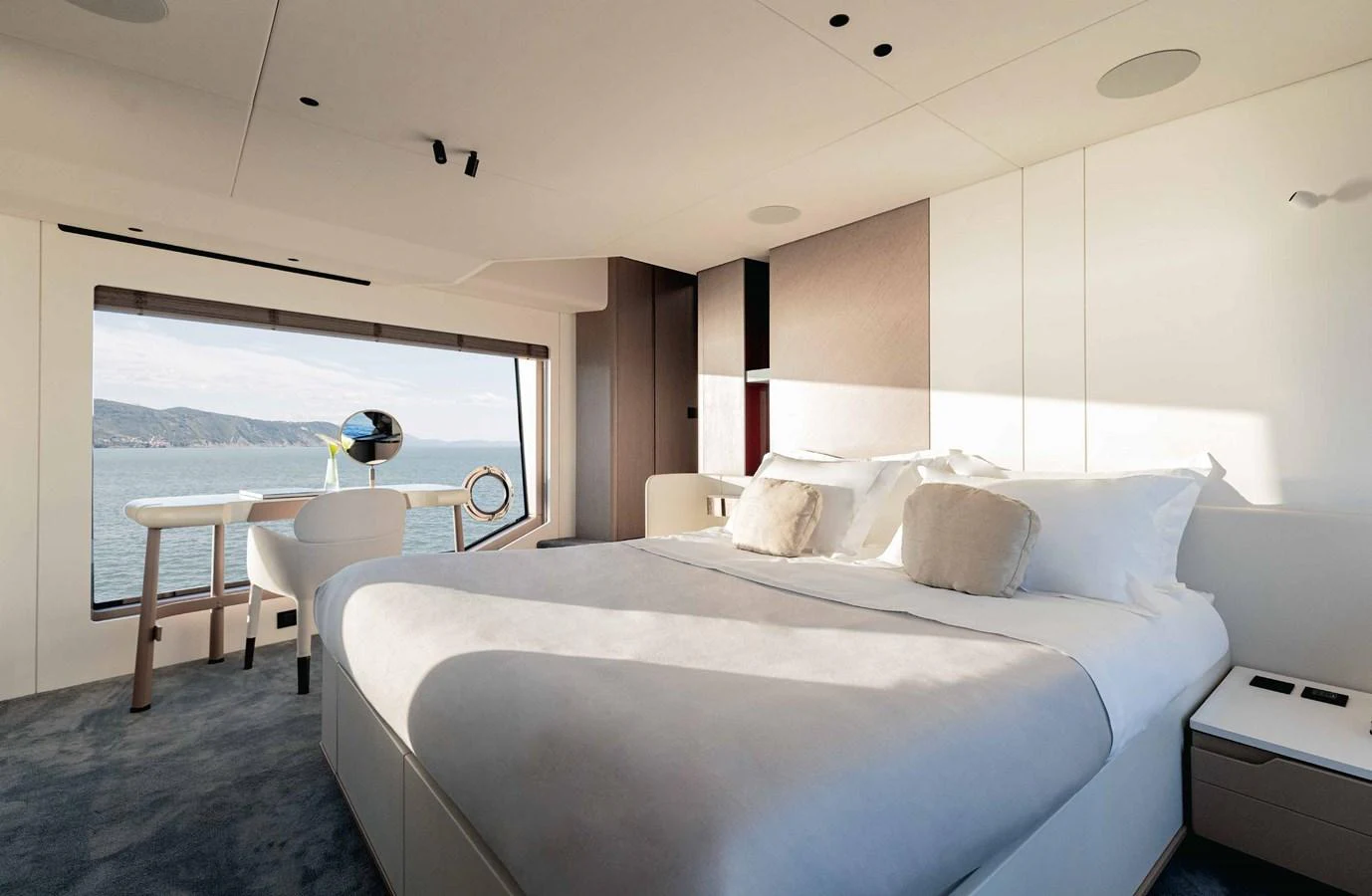 A luxurious stateroom with a large bed and a scenic ocean view through a wide window. aboard MARYBELLE Yacht for Sale