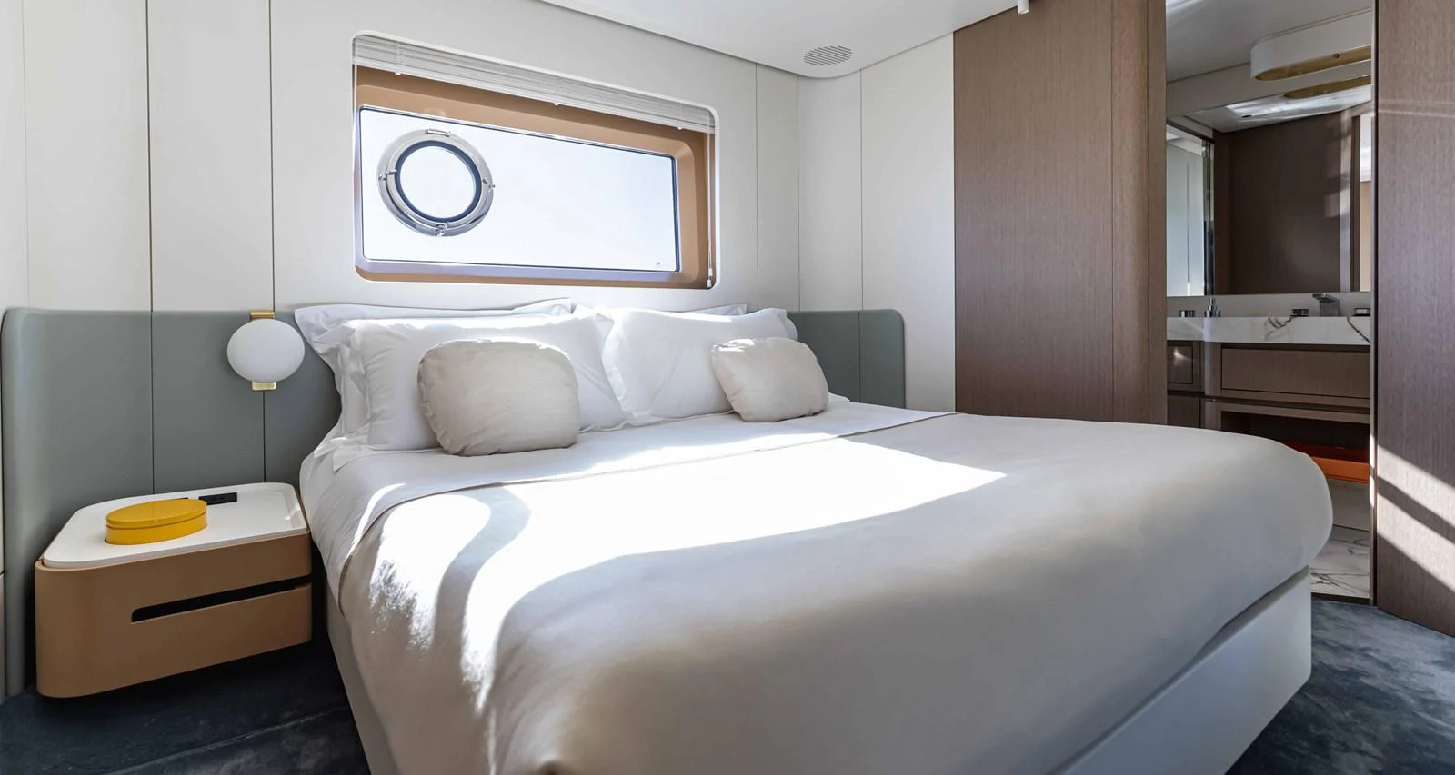 A luxurious stateroom featuring a large bed with plush bedding and a window providing natural light. aboard MARYBELLE Yacht for Sale