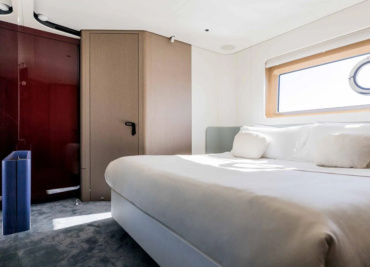 A luxurious stateroom featuring a large bed with plush pillows and a window allowing natural light to fill the space. aboard MARYBELLE Yacht for Sale