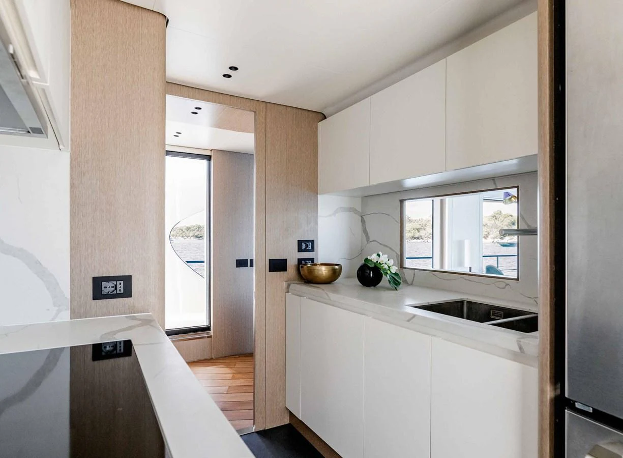 The yacht's galley features modern appliances and sleek cabinetry with a view of the sea. aboard MARYBELLE Yacht for Sale