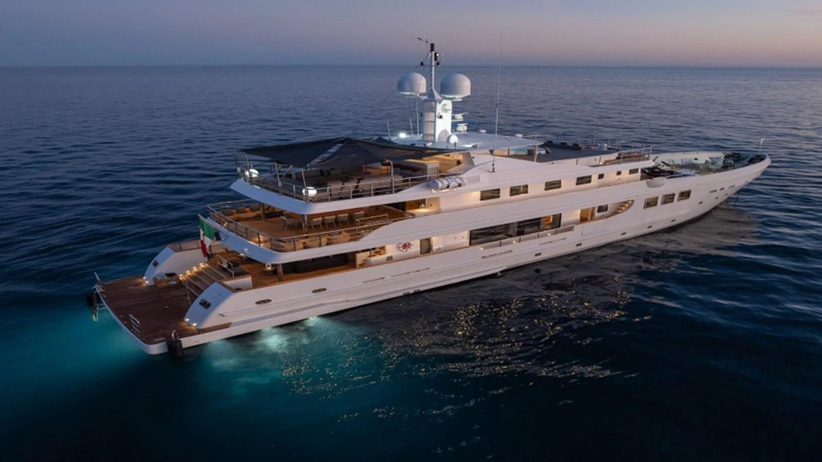 A luxurious yacht cruising at dusk, showcasing its elegant design and spacious decks. aboard R23 Yacht for Sale